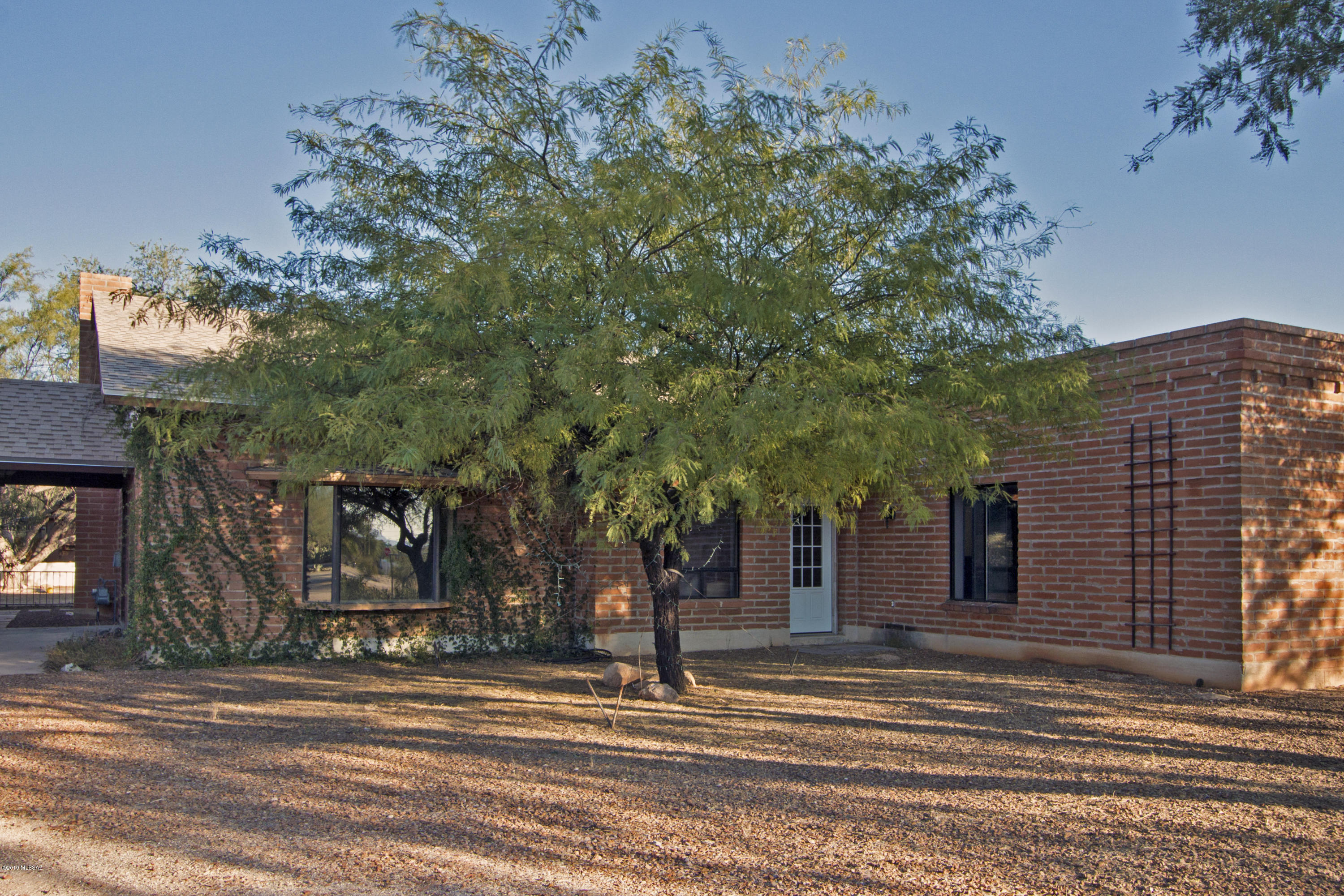Burnt adobe, single story home with separate guest quarters nestled on a large private lot. Being sold AS IS, this fixer-upper allows you to renovate with the maximum freedom to create a home that suites your needs. The price includes thought about upgrades necessary to remodel. Original vintage rustic charmer includes formal dining, spacious family room warmed by a gas fireplace and centrally located kitchen with stainless appliances. Large master suite with slider to rear covered patio area. Additionally, two bedrooms in main house share a Jack-and-Jill bath. Off the kitchen is an open space that currently serves as an office. Across the breezeway, the guest quarters with private entry houses a one bedroom and bath retreat. Over-sized garage provides additional storage and workshop.