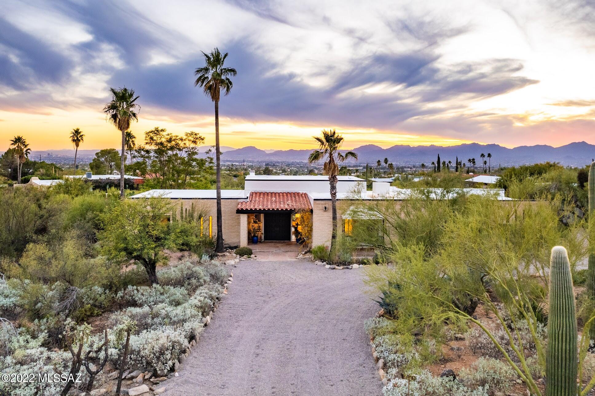 Fabulous contemporary foothills home thoughtfully renovated with designer finishes & flare. Greatroom  style with the ever-popular split bedroom plan; 4BR/3 BATH, dramatic, high ceilings, clerestory windows, walls of glass & corner Fireplace. Updates include beautiful concrete overlay floors throughout w/new carpet in primary suite, walls removed, ceilings raised, interior/exterior paint, tile, backsplash, wallpaper, complete redesign of kitchen, new SS appliances, countertops, lighting, fixtures, hardware, toilets, sinks & new Butler's pantry. Amazing outdoor living includes multiple patios as well as spacious backyard oasis. Circular driveway, 2 car garage, MT, CITY & SUNSET VIEWS! Only 2 small steps between Greatroom & Kitchen*SEE UPDATE LIST*Owner is a licensed RE agent in AZ(inactive)