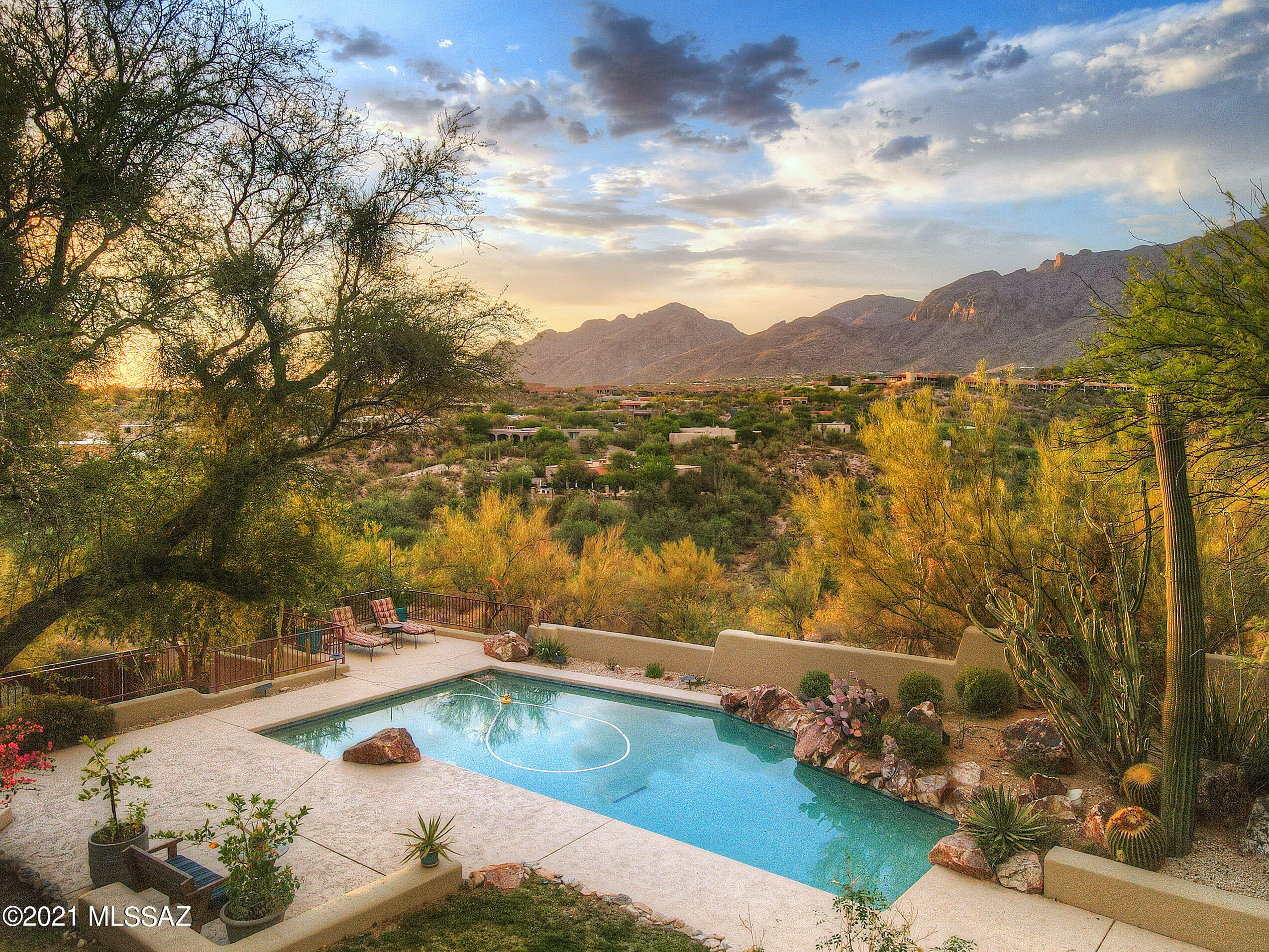 Enjoy sweeping mountain views and natural light from floor-to-ceiling windows on your private cul-de-sac hilltop lot. Gracefully remodeled to add warmth and charm to this contemporary open-concept Tyson Murphy design, this home offers 4 spacious bedrooms, 3 baths and 2 living rooms. The two bonus rooms could serve as additional guest quarters, den, or media/game room. The 14 foot ceilings are accented with architecturally significant wood beams. When not relaxing on one of five covered patios, wash away the stress of the day in the north-facing backyard oasis, complete with pool and built-in BBQ grill. The chef's kitchen offers high-end stainless appliances, prep island and breakfast bar. Not in the mood to cook? Take short stroll over to Hacienda Del Sol resort. The lifestyle you deserve. Additional features include three fireplaces, a massive garage and adjacent carport, extensive interior storage, and an artist-fabricated fence and gates.