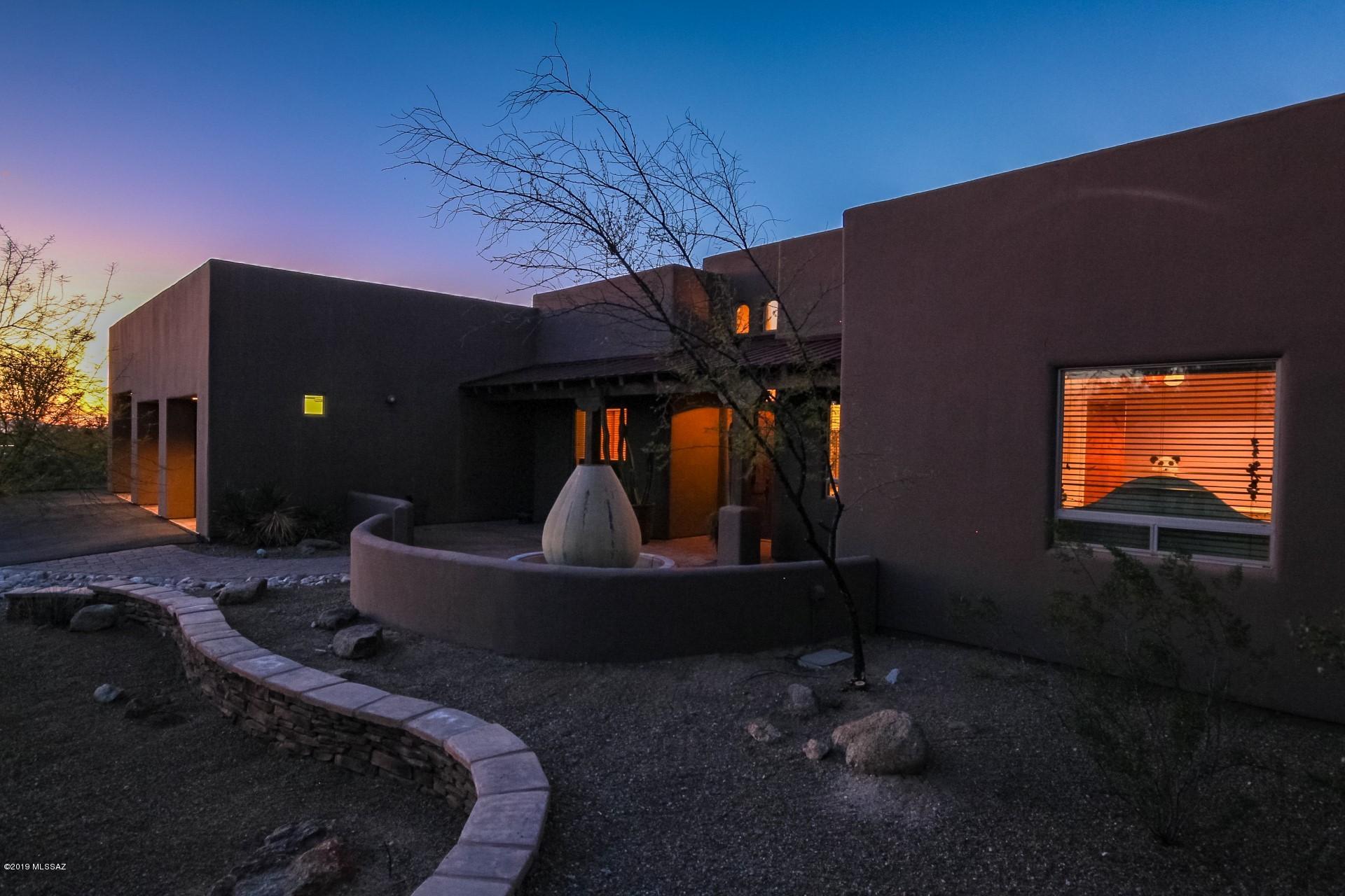 Seller will accept or counter offers between $800,000-$825,000. Your exquisite custom home with spectacular upgrades and views await!  This home has every upgrade imaginable and all have been executed with the utmost taste.  The private courtyard and custom garage doors greet you upon entering the property.  The Contemporary Santa Fe style home seeks to impress!  Built-ins, plant shelves and stunning concrete floors and countertops are only a few of the features of this home!  Custom paint palette, exposed distressed beams and the open floorplan set this home aside from all the others! 1400 sqft 4 Car Garage with room for RV. 4 bed + office, 5 ba split floorplan. Office is separate w/bath, 1600 sqft covered patio, Pebble Tec Pool, Spa w/ waterfall, Outdoor Kitchen for summer BBQ's while enjoying the absolutely gorgeous fireplace on those cool AZ nights. This kitchen is perfection boasting a huge farm sink, island and custom cabinetry. The custom backsplash and pantry add that special detail. This master suite hosts a corner fireplace, walk-in closet and double sinks.  The elevated garden style tub and walk-in shower create your personal spa like sanctuary.  Every detail of this home is immaculate! Find the three bay garage with an oversized door, stained concrete flooring and supersized, ready to meet any expectations you may have.  The guest suite will more than embrace your family and friends.  Take a walk outdoors and take in the covered patio, sparkling resort style pool and built-in BBQ and bar.  A children's playground exists right in your own backyard!  Spend the evenings out on this massive patio, relax and watch the sunset against the mountains. 4500 W. Corte Sombra Del Tecolote is calling you home. This home is the retreat you have been looking for! A home of this caliber wont last! Schedule your private tour today!