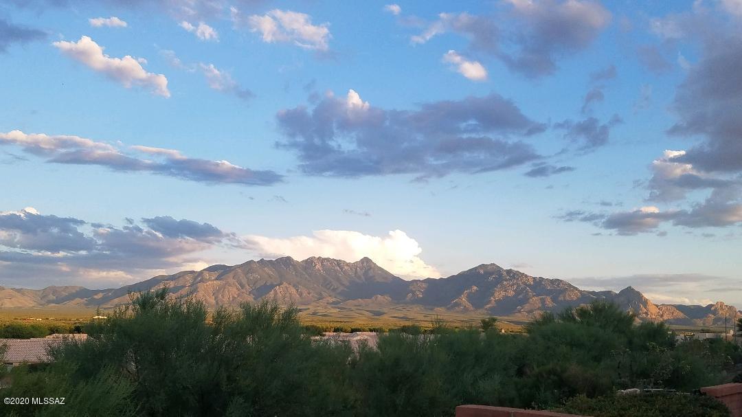 Grab this one while you can! Gorgeous panoramic mountain views from great room, master suite & den. Split BRs give guests their privacy. Lovely breakfast nook plus dining area with Talavera tile accenting an arched pass through to the kitchen.  Fab gourmet kitchen touts saguaro rib cabinet fronts, full slab granite, Electrolux 5 burner gas range & Advantum MW both with convection cooking, Bosch DW and brand new French door, bottom freezer SS fridge. Laundry room is off kitchen. Garage is complete with cabs, wk bench and air conditioning! All ceramic tile flooring, high ceilings, recessed lights, interesting architectural lines & centrally positioned gas log FP. This owner enjoys painting in the den while the vistas inspire her. Sip your morning coffee on the fully covered patio completed w ith cobblestone pavers and raised beds. Trane heatpump & water heater approximately 3 years old.   Sunrise Pointe is a gated community with sidewalks. The community pool is about a half a block down the street.