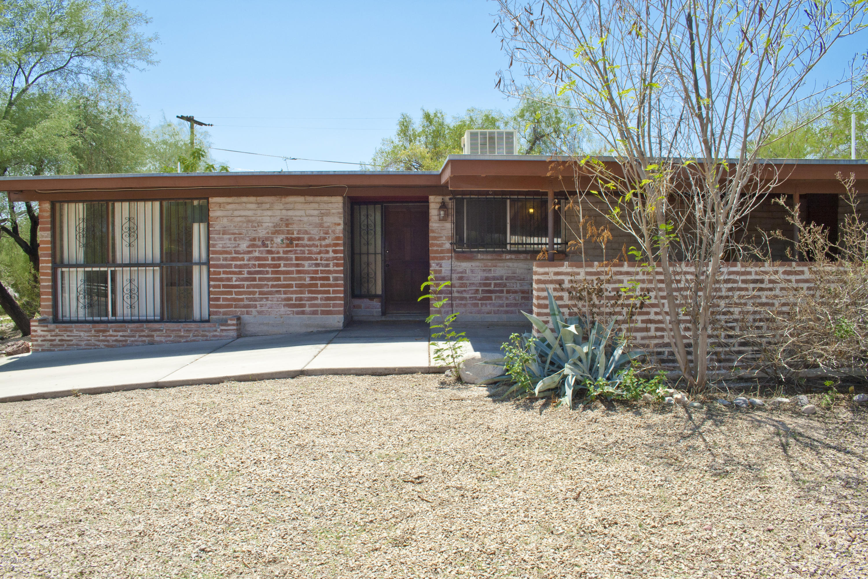 This light, bright centrally located brick charmer has a new roof from 2016 & upgraded electrical 2014. Enjoy the private south-facing backyard on your large corner lot with mature shade & citrus trees and a vegetable garden. The attached carport includes a huge storage room with windows & electric which could double as a workshop. Set back from Grant Road, a large block wall was added to the front yard for additional privacy while still providing great Catalina views from the sunken living room & third bedroom. Located just minutes from Udall Park, Tucson Medical Center, Tanque Verde's ''Restaurant Row,'' and access to The Loop's 120 miles of shared-use paths, this home is also convenient to BASIS Tucson North & the Catalina Foothills School District with its open enrollment policy.