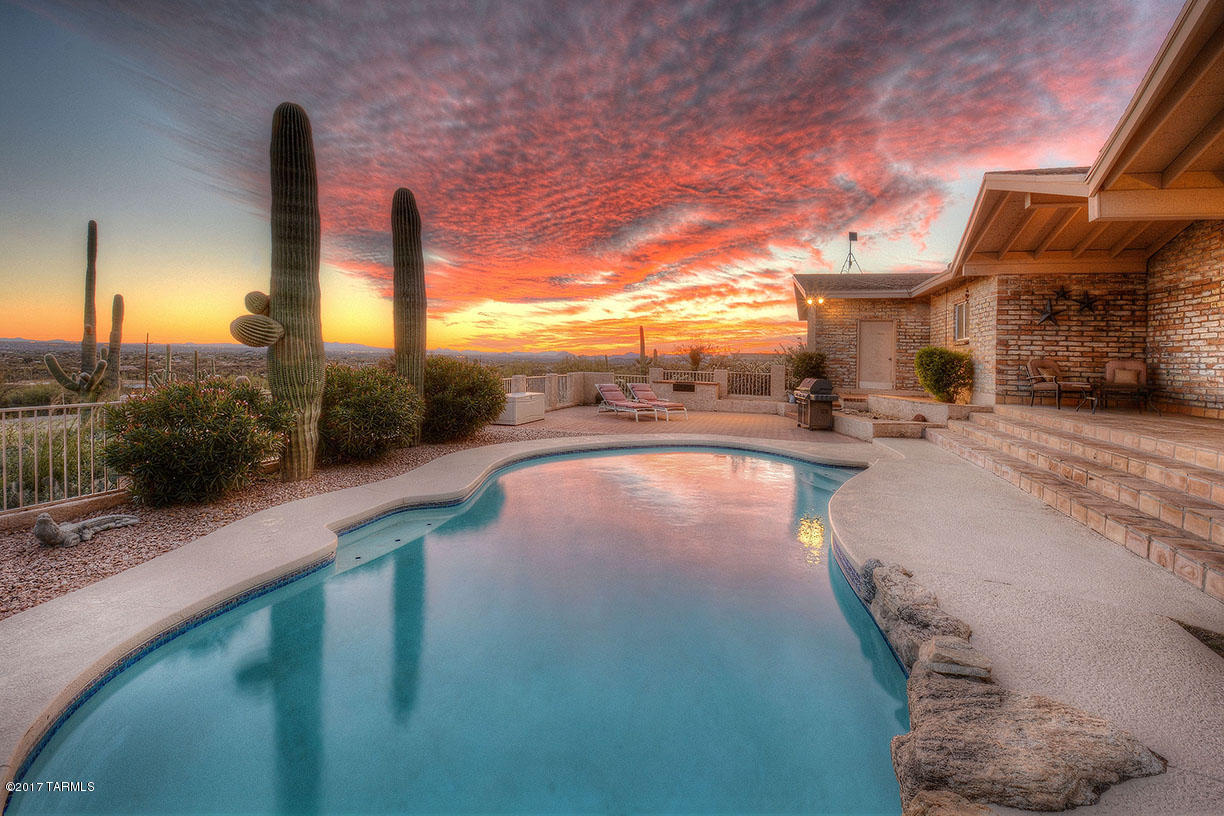 Seller will accept or counter offers between $525,000-$550,000. AMAZING CITY AND MOUNTAIN VIEWS!!! This beautiful single story home has an oversized ATTACHED 2 car garage, an oversized DETACHED 2 car garage, 2 car carport, POOL and HORSE FACILITIES. Home is situated on 2.64 acres at the base of Mt. Lemmon with the Coronado National Forest to the East. 4 bedrooms, 4 bathrooms, updated kitchen, updated baths, separate living areas and formal dining are just a few of the unique characteristics of this Luxury home. One bedroom and bath located on West wing of home could be used as 'guest quarters'. Home has extended side driveway with room for RV, TOYS and guest parking. Enjoy views of the city lights, mountains, pool and horses from your covered back porch. This home has it all!! Both AC units have been replaced in the past 5 years. Seller is offering a flooring allowance with acceptable offer!