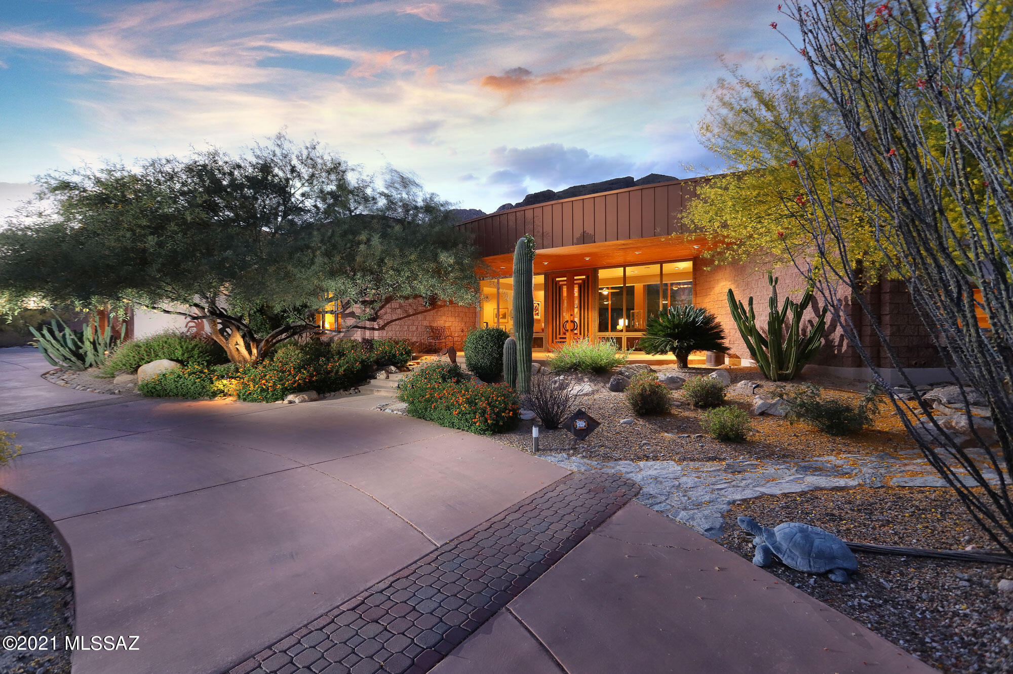 This luxurious home is tucked away at the end of a private cul-de-sac at the base of Catalina Mountains, in the highly sought after subdivision of The Enclave at Pima Canyon/Sin Vacas.  It was designed by award winning architect Rob Robinette.  The circular drive-way encircles a peaceful Koi pond, fountain and shaded sitting area which welcomes you into the covered entry terrace frames the artistic glass/wood/metal double entry doors.  The spectacular design encompasses the Sonoran Desert's unique beauty and views of the Catalina Mountains from the walls of windows, across the stunning living and dining area. 3 spacious bedrooms, plus guest quarters off garage with full bath, elegant office, timeless travertine flooring in main living area.  Master features his and her master closets. Gourmet kitchen has opened design, stainless steel upgrade appliances, gorgeous island and large breakfast gathering area with additional views of the Catalinas. Extensive covered patio wraps around the entire rear of the home, perfect for entertaining or enjoying tranquil desert evenings.  The roof deck provides 360 degree views of the Tucson Valley and its many mountain ranges and an extraordinary view of Tucson's shimmering lights and/or star gazing, at night.  

Two gas fireplaces, recessed ceiling with soft lighting, and some of the multiple art niches throughout the home. Breakfast table in the well-appointed kitchen where you can enjoy more top-of-the-mountain views across the handsomely landscaped rear terrace, through more floor-to-ceiling windows. Enjoy a full suite of GE Monogram Advantium Series stainless appliances including oversized refrigerator, cooktop, convection microwave and oven, warming drawer and wine refrigerator, all set into elegant black granite and rich maple cabinetry in a timeless contemporary style. The island includes a breakfast bar with raised etched glass counter, and the glass door to the walk-in pantry echoes this elegant design. A kitchen desk area, with more views, is convenient for daily tasks. The rear terrace outside of the kitchen has covered seating adjacent to a large bbq area with additional burner, sink and refrigerator, a fire-pit with bench seating, and plenty of room to add a fabulous pool looking up to the mountaintops. A nearby powder room is beautifully done, with curved walls finished in beautifully shaded Venetian plaster, handsome curved black granite counter, glass vessel sink and an elegantly recessed ceiling feature. A pentagon-shaped master suite provides more floor-to-ceiling views of mountain tops, another coffered ceiling with soft romantic embedded lighting, and glass doors to a private patio with hot tub. The master bath is spacious, with more black granite counters including a seated make-up area. An oversized jacuzzi tub awaits for relaxation, while the walk-in shower provides multiple water sprays. Two large walk-in master closets. Next door is a spacious office with a handsome wrap-around built-in desk, Murphy bed, closet and extensive storage options, including floor-to-ceiling book shelving, with views of Tucson's city lights. Two additional bedrooms, one with ensuite bath, and a large laundry room with built-in ironing board and plenty of storage, are on the other side of this beautiful home. The oversized 3 car garage is also special, with finished floors, more beautiful cabinetry, an attractive workbench area and three closed storerooms, the garage has a 220 volt outlet to charge your electric car if needed. Air conditioned guest room/gym room with a full bath boasting a private steam shower has private entrance off garage. This unique home, is built with steel frame construction and 20' ceilings, Two owned solar systems provide electricity and hot water (Electric bill as low as $14, average $95 and high $260). Three AC units provide ample cooling. Window coverings for those elegant floor-to-ceilings are remote controlled, and there are outdoor remote controlled exterior sunscreen shades as well. Ceiling fans are found throughout the home, as is large-format travertine tile in all areas except bedrooms. Skylights throughout the home are opened by remote control. A high-quality one-of-a-kind home. Although secluded, this neighborhood is very  friendly, and neighbors are seen daily visiting and walking their pets. There is quick easy access La Encantada's arts, dining and shopping area, the "Whole Foods" corner and downtown Tucson, with excellent restaurants, cultural events and outstanding medical facilities. Please call to arrange a private showing.