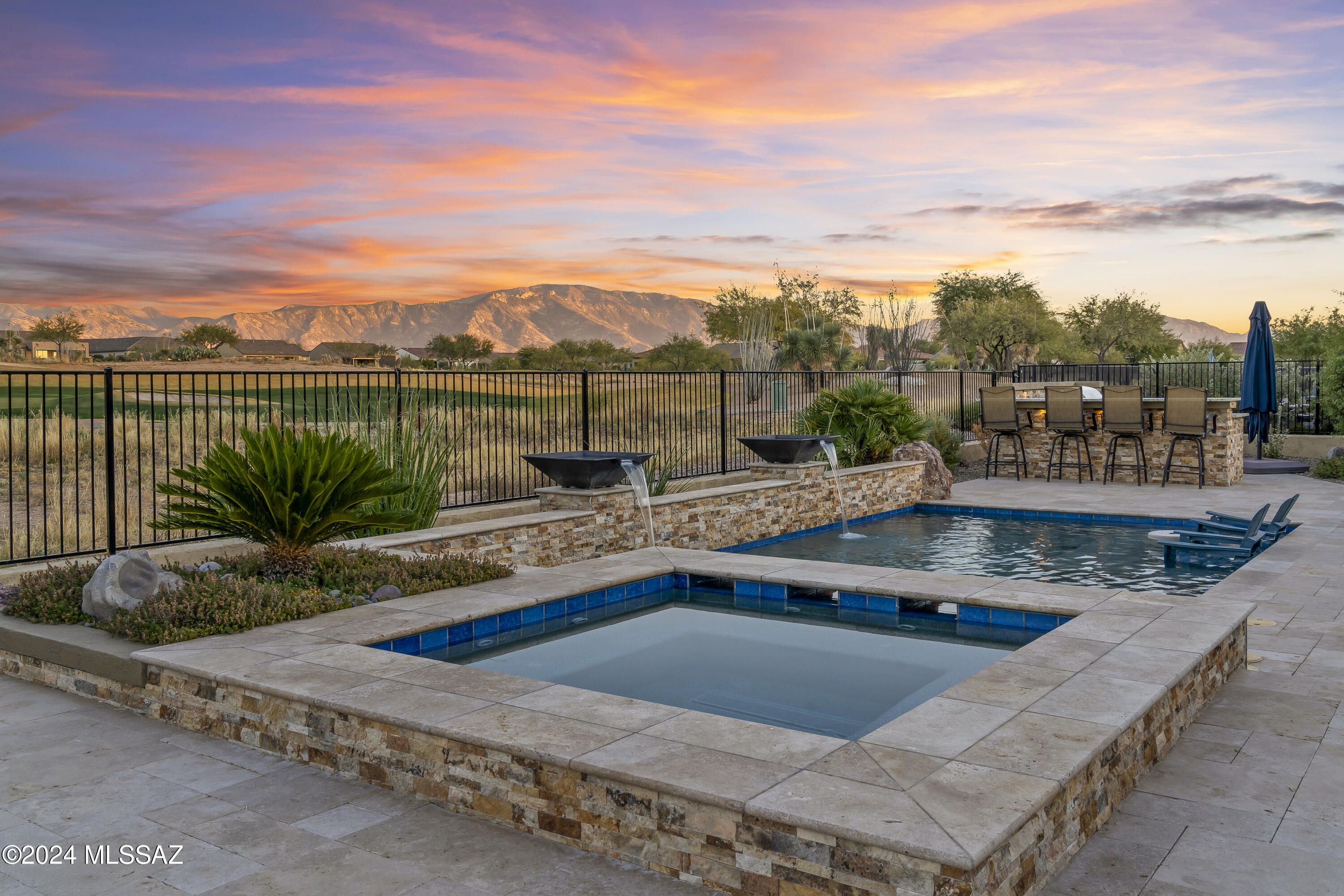 Rare Opportunity in SaddleBrooke Ranch with Stunning Golf Course & Catalina Mountain Views! This exceptional home is the sought-after Vienta floorplan & highly upgraded. An open & airy layout w/chef's kitchen has a gorgeous island, large walk-in pantry & gas cooktop. The primary suite features more magnificent views & an ensuite bath w/soaking tub & separate shower. The split floorplan ensures privacy for all. Glass French doors lead to an oversized den. Outside, the backyard is a true showstopper with the custom designed pool w/spa, unique water features, lighting & popular Baja deck. The built-in BBQ has bistro seating & the covered patio offers a gas fireplace & is wired for TV. With outdoor speakers adding to the ambiance, every evening will feel like a special occasion. All this plus a full-size 3-car garage. All interior cabinetry is upgraded including soft close doors & drawers. Full height tile backsplash in kitchen.  The primary suite has an expansive walk-in custom-designed closet. Guest bedroom is ensuite with walk-in closet. Coffer ceilings in primary bedroom & den. A wet bar with a wine fridge in the great room adds the perfect touch for hosting guests. The large laundry room has full built-in storage & a utility sink. There is a beautiful custom wall unit in great room. Plantation shutters and designer lighting throughout the home. The extended garage is finished with an epoxy floor, built in storage cabinets & keyless entry pads at both garage doors. The yard is fully fenced with a gorgeous travertine patio & remote-controlled rolling solar shades & producing peach & apple trees. With its prime location, stunning views, and countless upgrades, this home offers the best of SaddleBrooke Ranch living. Whether you're looking for a peaceful retreat or an entertainer's paradise, this home has it all. The combination of luxurious features, spectacular outdoor spaces, and a vibrant community make it a truly rare opportunity.
Don't miss out on the chance to own this one-of-a-kind home!