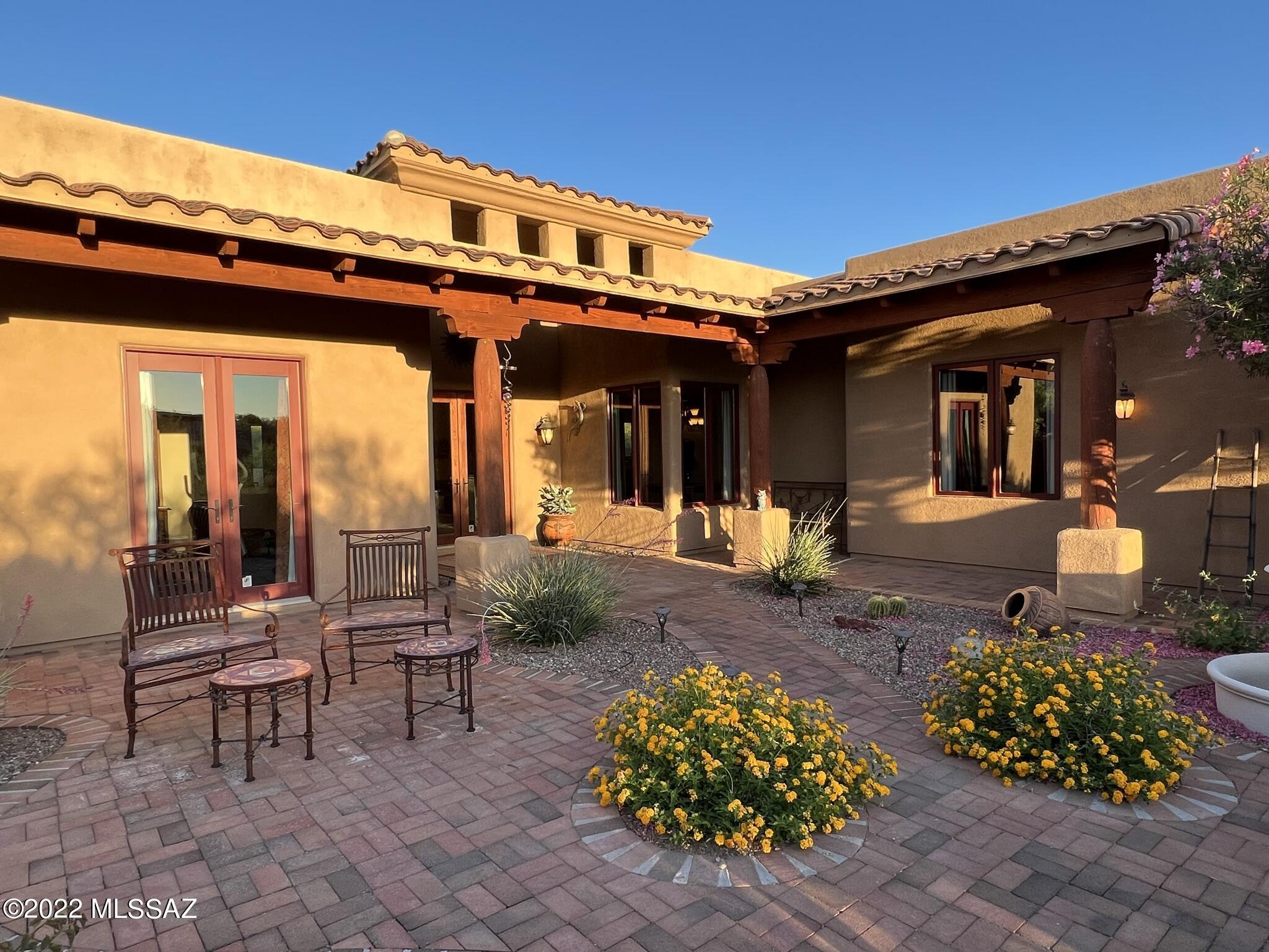 This Spanish l / Santa Fe style home is located in the gated section at the end of a cul-de-sac and set well back from the road. Split bedroom plan with 2 masters and a study with closet (poss 5th bdrm). Guest room bath has outside entry and doubles as pool bath. Geat room offers sunset views on one side and mountains on the other. Wood planked ceilings, rough sawn beams and posts abound inside and extend out into the natural brick paved front courtyard and wraparound patio.  A refrigerated 400 bottle wine room sits adjacent to the formal dining room. The kitchen is a chef's dream with cherry cabinets, granite countertops and SS appliances. 8 ft wood doors are everywhere. Laundry room has plenty of cabinets, Large heated pool and spa. Oversized 3 car garage. 
Owner is licensed AZ agent,