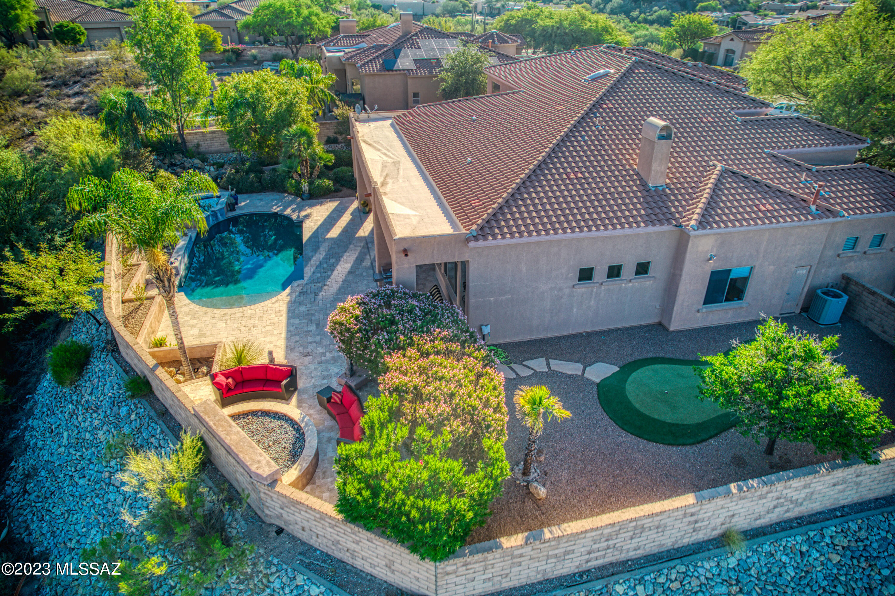 Recent updates to this luxury foothills home located on a premium lot in Paloma Canyon with unobstructed breathtaking views of Finger Rock and the Catalina Mountains.  Home overlooks a desert common area studded with majestic saguaro cactus.  Relax on the covered travertine patio of this backyard oasis... listen to the waterfall, take a dip in the pebble tech pool, soak in the jacuzzi or just unwind by the built-in gas firepit with your favorite beverage and watch a stunning sunset. With only a neighbor to the east, this property affords maximum privacy. There is a three-car garage, even a mini putting green!
The backyard patio doors open to a spacious great room with a tiled gas fireplace. The adjoining kitchen features granite countertops, brand-new stainless steel appliances with induction cook top.  Laundry equipped with washer / dryer, spacious linen closet & overhead cabinets. The exterior of the house and perimeter stucco backyard wall re-painted in Nov. Interior rooms: foyer, dining room, living room, office, great room, & kitchen all freshly painted.  Brand-new commodes in all bathrooms & a new water heater installed Dec. 2023. 3 car garage with electric hook up.