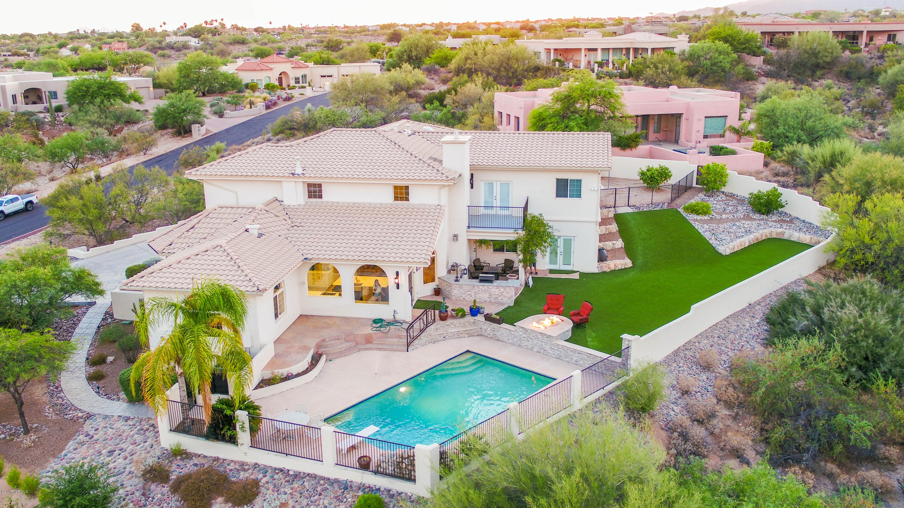 Spectaucular 6 plus bedroom custom home in gated community of Canada Hills Estates.  Amazing views of the Catalina mountains, Pusch Ridge and city lights.  This house has been completely remodeled including:  New gourmet kitchen with new white cabinets, countertops and appliances. New flooring, front doors, wrought iron bannister, fireplace, stone work trough out, lighting, window treatments and more!  This house has a 2 master suits, large laundry room,  a second walk in pantry.  A very hard to find basement/man cave that has 2 bedrooms, one bathroom and a media room in it.  Entertainers backyard with pool, fire pit, 2 barbecues, water feature, artificial grass and stunning views of the mountains.  This house has it all, a must see!!!