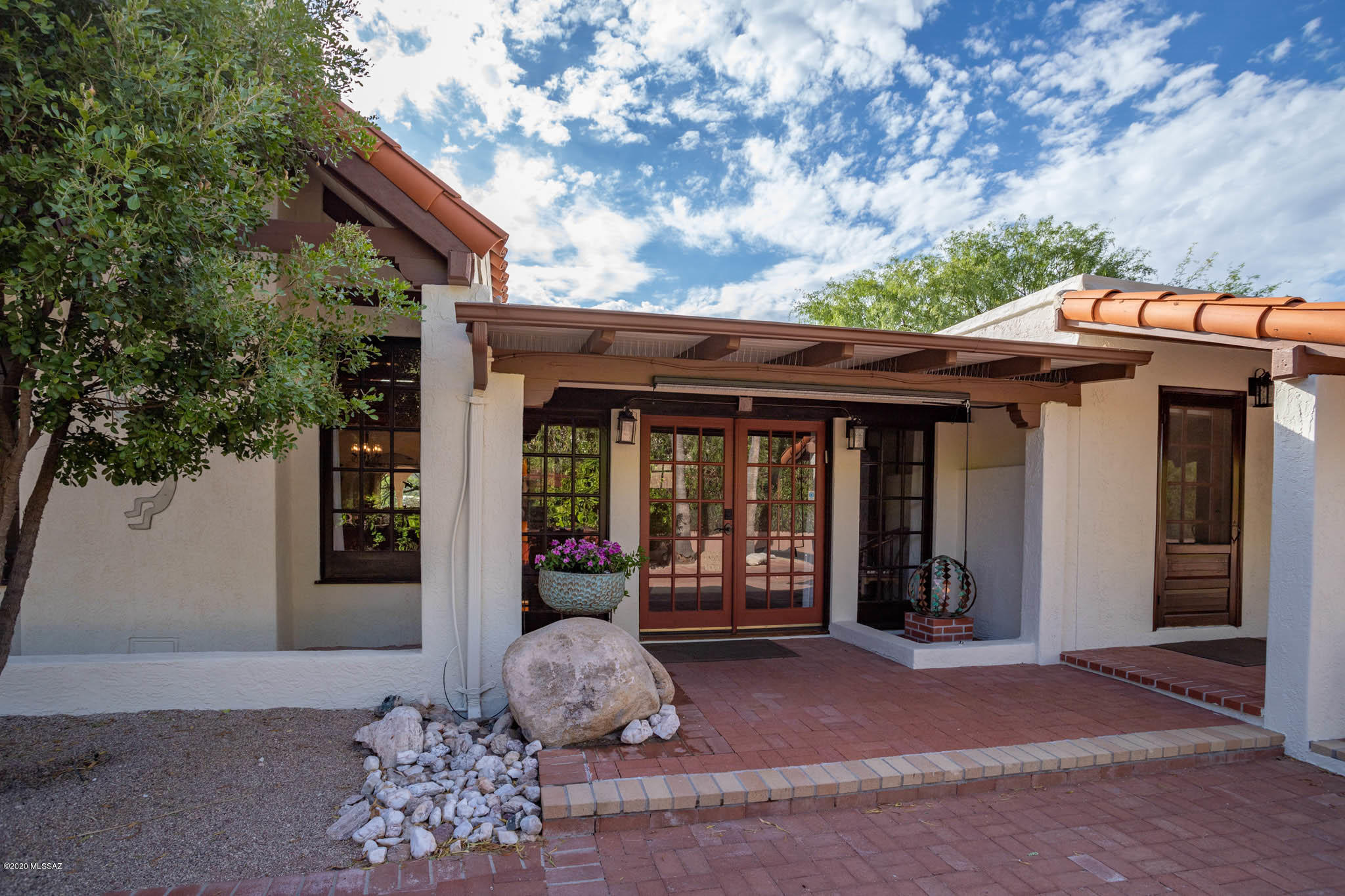 Stunning, gated, luxury property on 5 acres in Foothills. Breathtaking mountain and city views from inside the house and from the wrap around covered patio. Totally remodeled, solar powered, home with custom Alder and Mesquite wood doors, beams, brick /tile floors, fabulous Chef's kitchen with 6 burner gas stove, Thermador appliances, granite and marble countertops, cherry wood cabinets, walk-in pantry. Master bedroom has a rock fireplace, access out to its own patio to enjoy the gorgeous mountain views.  Huge guest quaters with a fireplace, southwestern bathroom and access out to both south and west patios. Separate bunk house for extra guests. Solar heated pool, ramada, fruit trees, vegetable beds, your own graveled walk trail at the back of the property and so much more.