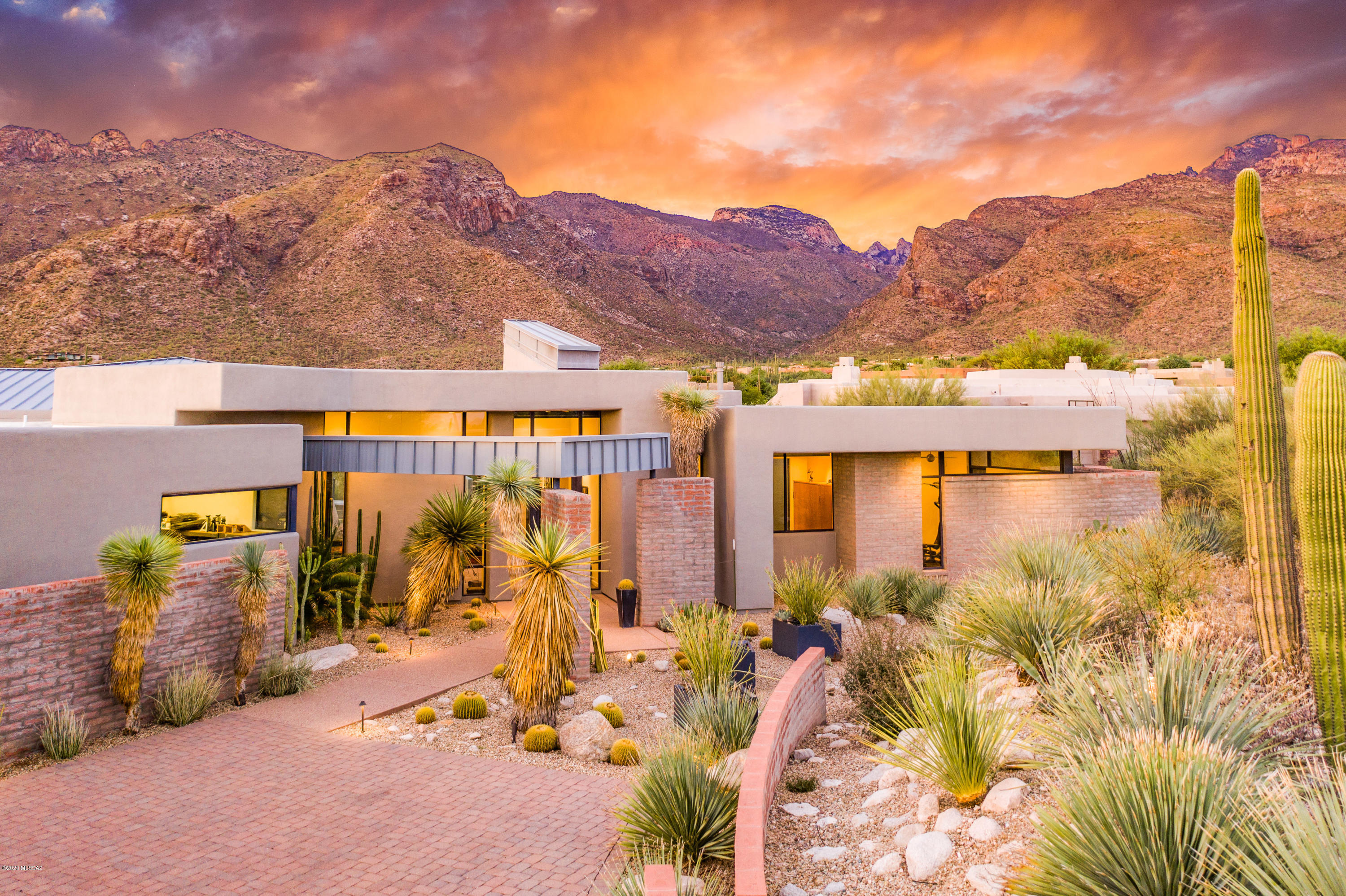 Undoubtedly, one of the Finest examples of Desert Modern Architecture in Tucson! This dramatic work of art is a perfect blend of cutting edge contemporary design and refined elements, creating a sophisticated living environment. Perfectly situated on one of the finest view lots in Pima Canyon Estates, the magnificent floor to ceiling windows capture the mesmerizing views from every room and allow natural light and nature in. Collaboration between the architect and artist owner resulted in a masterful floorplan designed for indoor/outdoor living, entertaining, and showcasing a fine art collection. The open great room features a custom fireplace & entertainment wall and leads into the Gourmet kitchen w/stainless steel & vibrant red quartz countertops, plus Wolf & Sub Zero appliances. More... Two en-suite bedrooms plus an owner's suite w/spa like bathroom, office & exercise room. Step out to the rear patio and be awed by the drama of the Catalina Mountains towering above, a sparkling pool & spa, built in grill, lush lawn & mature specimen landscaping. Be the envy of every car collector w/the 1,220sq.ft, 4+ car garage w/workshop, & every artist's dream studio w/natural north light and captivating views.