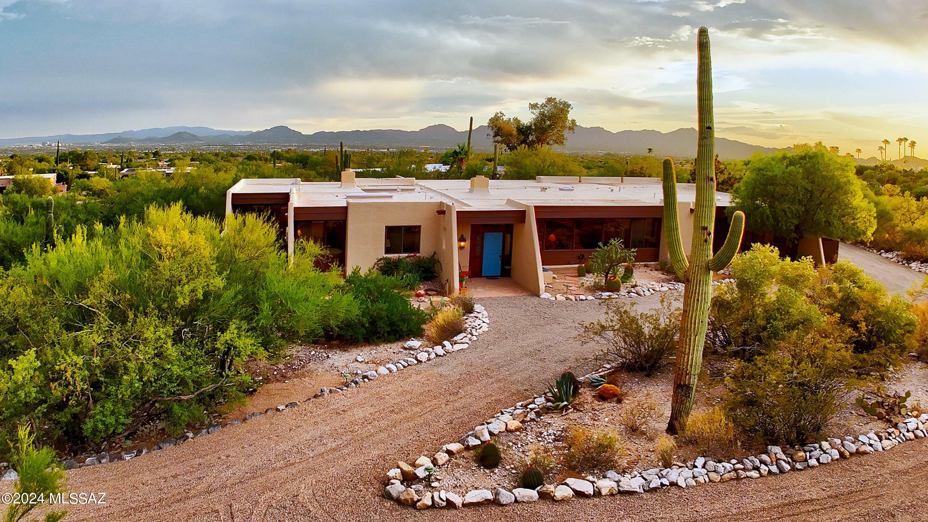 With stunning wall to wall mountain views to the north & city lights to the south looking over a sparkling pool, this quintessential Tyson-Murphy home oozes w/Tucson charm & elegance. Enter into the beautiful living & dining rms w/gorgeous exposed wood beam ceils, a 2 sided FP and a fantastic view of the Catalinas. Saltillo tile takes you into the great rm w/those city views &  then the classic kitchen distinctive to the builder. Primary Ste has 2 cedar closets, sep shower, soaking tub,  gorgeous brick FP & its own access to the pool.  All bdrms have updated cork flooring. Extra deep patio welcomes you to the bkyd oasis w/gazebo and pool.  Phenomenal bonus rm is being used as an art studio w/mtn views of its own. All this on a private&tranquil lot located in the heart of the foothil