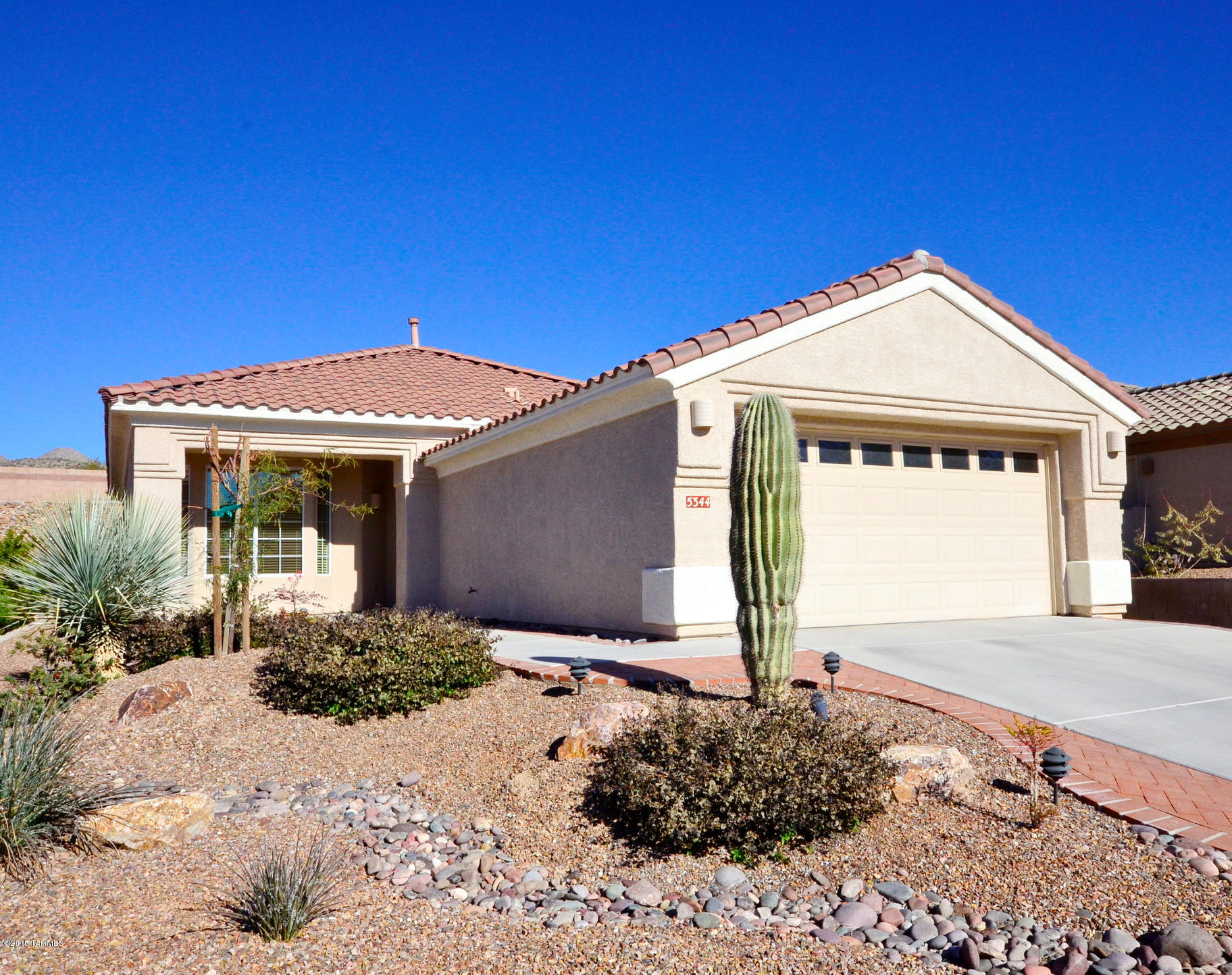 Immaculate 2 bdrm + den home that is completely move-in-ready - Expanded Durango model. Home is sparkling clean, w/fine upgrades. 18 inch tile throughout home except bedrooms, granite kitchen counters, backsplash, under-mount cabinet lighting, etc. Relaxing back yard w/firepit, fruit trees, & flowering desert landscape. This is a beautifully upgraded home.