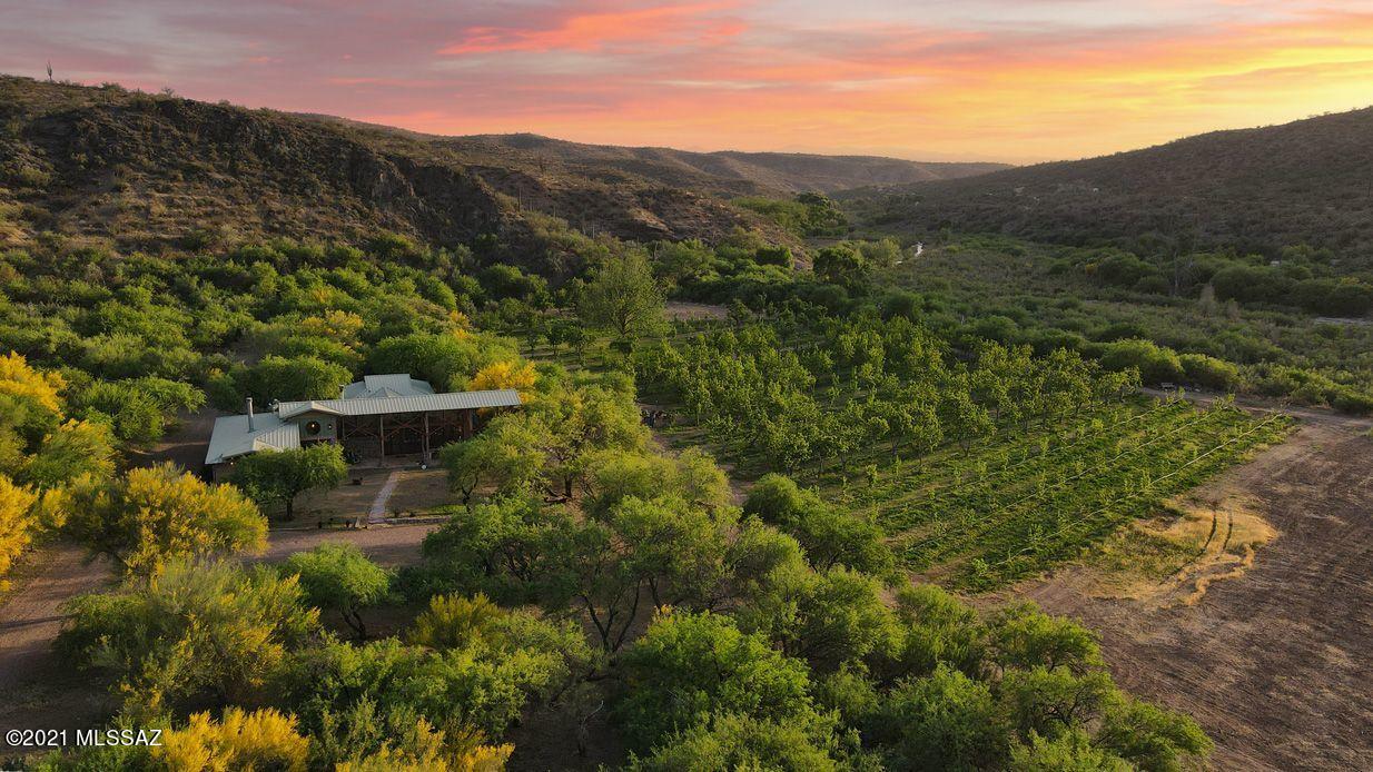 THE MOST MAGICAL PROPERTY IN ARIZONA IS NOW AVAILABLE! This is a remarkable opportunity to own a collection of beautiful homes & casitas, a fabulous main straw bale residence, a highly productive orchard, an organic garden, an extremely rare perennial creek with excellent water rights & a thriving, turnkey boutique hospitality business. All of this is set on 47 deeded acres in the spectacular riparian preserve of Aravaipa Canyon located only 1.5 hours from Tucson & 2 hours from Phoenix. The ''ARAVAIPA FARMS ORCHARD AND INN'' has been lovingly improved, managed & positioned for success. It has huge potential in its current state or it easily could be perfect fit for a wellness or treatment center, a small production farm & orchard or an incredible family compound, endless possibilities... In addition to the 3 bedroom, 3 bath lovely straw bale main house, there is a wonderful 3 bedroom, 2 bath farmhouse, a multi-purpose building with a commercial kitchen, gift shop, office, laundry, storage & dining room. There are also 5 charming casitas, a fantastic ramada, a large often used shop building, a new managers home, a sparkling, heated pool and a chicken coop! There are countless welcoming porches and patios and fireplaces are many, inside and out. The orchard is home to 930 productive fruit trees mainly made up of apricots, peaches and pears in 54 rows on 13 lush irrigated acres. The orchard is just now maturing into its highly productive years for decades ahead with potential annual income of over $50,000 a reality soon. There is also an 11,000 square foot organic garden. Water is provided from over 100 acre feet of excellent surface water rights dating back to 1899 from the spring-fed Aravaipa Creek. There are also four strong wells on the property.
69,600 acres protects this perennial stream, including the 19,700 acre BLM Aravaipa Canyon Wilderness Area and the 9,000 acre Nature Conservancy Aravaipa Canyon Preserve. All of this is 5 short miles away from the Inn. They limit the number of visitors into this pristine Preserve to only 50 per day. The Farm and surrounding area provide some of the best bird watching and hiking available in the country. Mountain bikers and star gazers will be amazed! The dark skies are unbelievable. There have been over 400 species of birds, almost 100 mammals and 100 butterfly species and close to 50 various reptiles and amphibians accounted for here.
The Aravaipa Farm is in such a special location the Nature Conservancy owns the land directly across the creek. This is truly a remarkable property. The sellers have created a rustic elegance that is very popular. It is a serene, relaxing, quiet, romantic, clean and comfortable, safe place. The Farm has delicious food, excellent service and an unforgettable experience for the guests. Just look at the reviews! The sellers have worked very hard to consistently improve the top line revenue and their branding. They produce income from room rentals, food, liquor, gift shop, fruit and vegetable sales. There is a great staff onboard. The sellers have done their part. Now the time is yours. This property is really primed for success! Come and see for yourself, you will not want to leave. DO NOT DISTURB OWNERS OR GUESTS! APPOINTMENTS ONLY. Airstream available on a Bill of Sale. P&L available upon request.