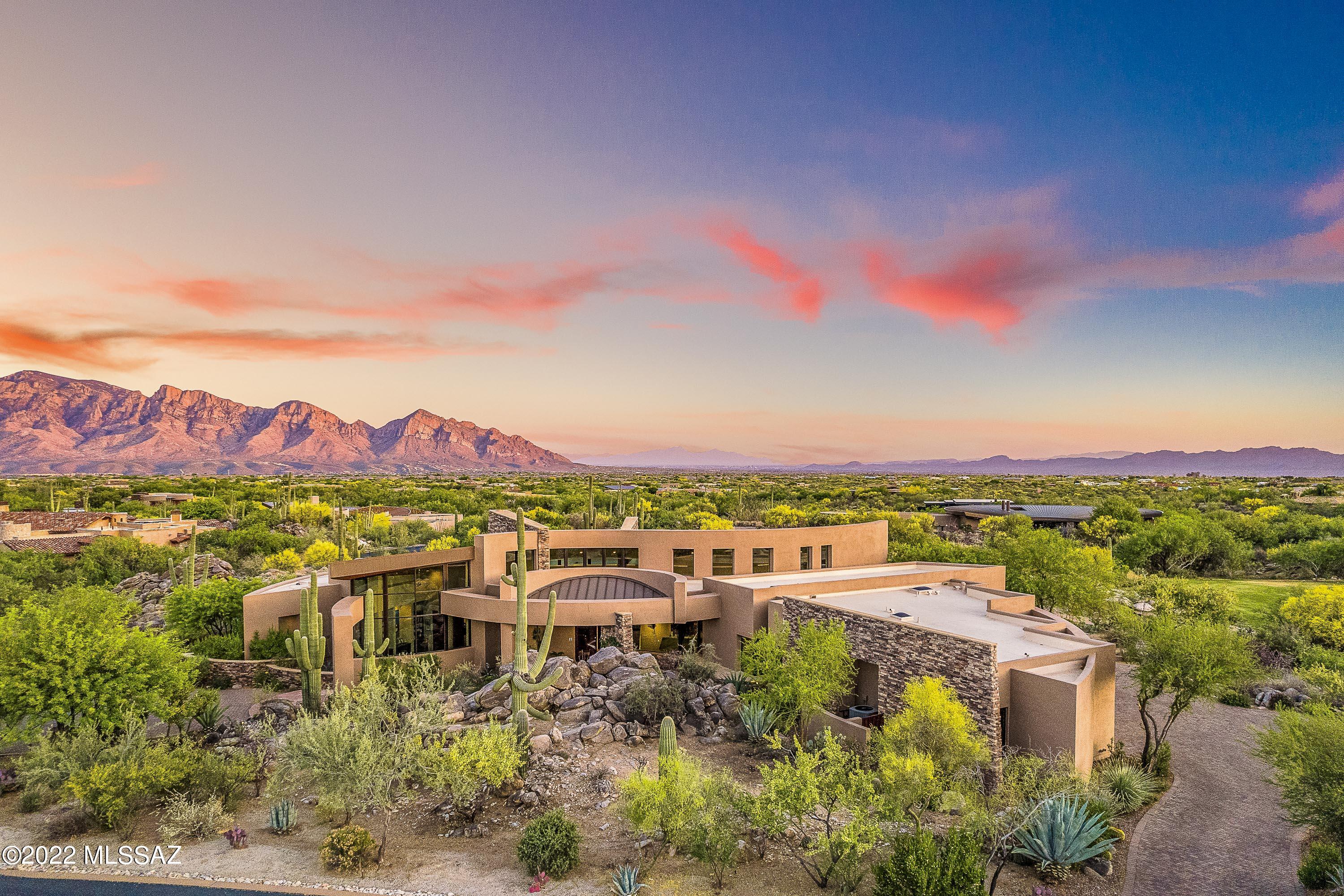 Striking contemporary designed by Kevin Howard with soaring ceilings and dramatic architectural features. Located on the famed Stone Canyon championship golf course with marvelous southeast views of the majestic Catalina Mountains and open desert. Bright great room with dining area and gourmet kitchen with Dacor appliances including warming drawer and prep island. Split layout includes 4 full suites, office, powder room, rec room, laundry room, and walk-in wine cellar. Relaxation-oriented yard with built-in BBQ, outdoor fireplace, self-cleaning saltwater pool & spa and gorgeous saguaro not to mention the stunning views! Perfect for vacation or year-round lifestyle: fabulous design, great location, luxury amenities, amazing scenery and guard-gated golf community in Oro Valley. Exquisite!