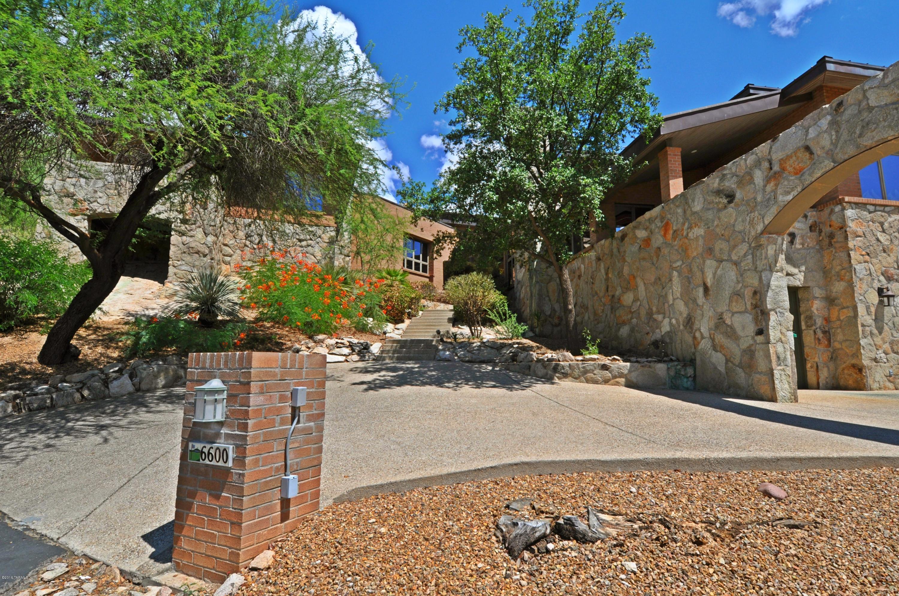 Top of Mountain Estates, end of the street, set on a dramatic, rocky precipice overlooking the Tucson valley below. Enjoy World Class Golf & an Arizona Resort lifestyle! Multiple living spaces, a kitchen w/views to die for, and a formal dining room fit for a state dinner! Two 2-room owner's bedroom suites-both with balcony access & fireplaces. A series of elevated walk-ways connect the outdoor space which includes patios/balconies/Built-in BBQ patio/covered pool/spa area. Tremendous appeal in the Frank LLoyd Wright-esque brick architecture and the stunning mountain setting! HVAC units replaced/renewed by seller. Copper Standing Seam Roof! See attachment for PAS requirements and WFHM offer submittal information in MLS document section. Please submit all offers to the listing broker/agent.
