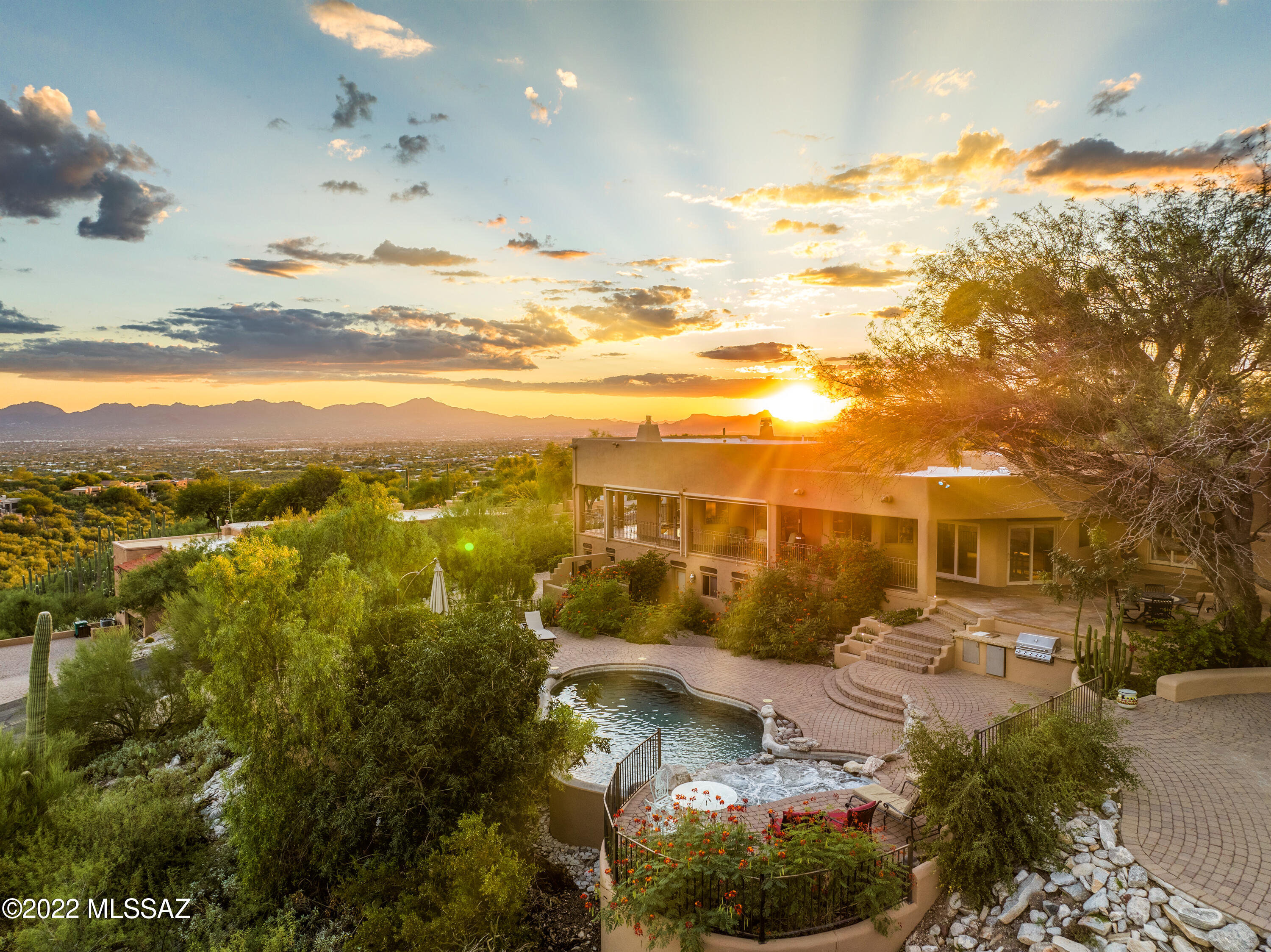 Rare opportunity to enjoy sweeping panoramic city & sunset views from one of the higher lots in Rancho Sin Vacas. Private & serene foothills community w/maned guard house gated entry. Minutes to La Encantada shops & fine dining. Open and spacious split plan, over 4,000 sq ft, loads of natural lighting. Lg gourmet kitchen island w/granite top, separate breakfast area. 4 huge bedrooms (3 w/den or 4th), 3.5 bath. Two master suites, one includes a sitting area w/cozy fireplace. Plus a secluded lower level bedroom with private entry. Perfect for guests or multi-generational living. Custom built home offers patios from 3 bedrooms. Awesome extended patio, outdoor fireplace, electric shade screens, overlooking BBQ & infinity edge pebble tech pool spa. Captivating mountain and city views abounds Exterior freshly painted and a 5-year roof warranty.