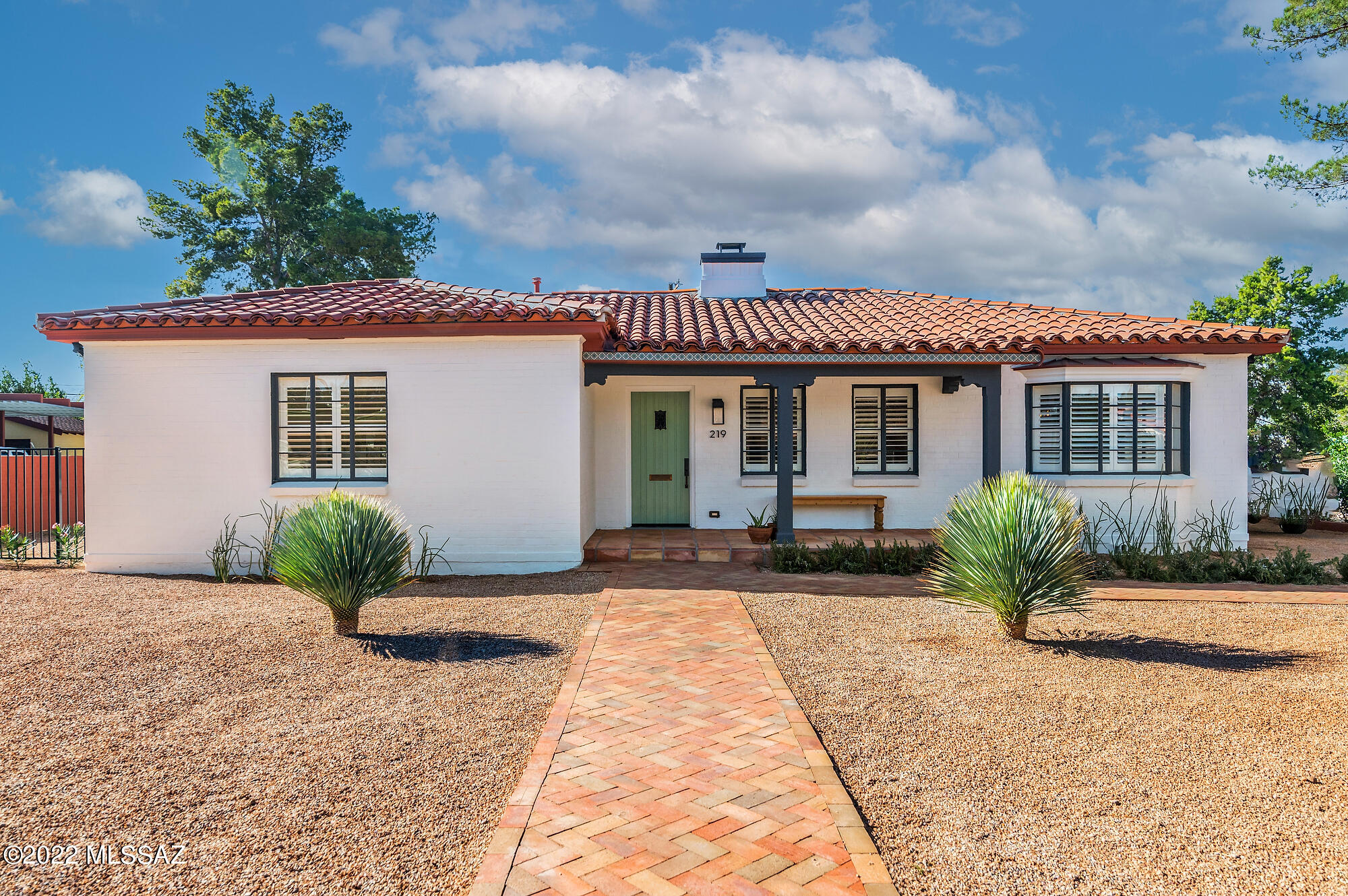 This 1940's Spanish Bungalow in Historic Catalina Vista has been meticulously updated, seamlessly blending new systems and modern conveniences yet still maintaining its original charm. The kitchen features custom cabinetry, quartz countertops, custom tile backsplash, and Kitchen Aid package of appliances. Authentic Hardwood floors have been refinished throughout the house and feature their original white Oak wood in a luxurious satin finish. Plantation shutters, Spanish tile & marble accents, and designer lighting all contribute to an unparalleled level of styling and sophistication. Three spacious bedrooms all have their own adjacent bathroom with extraordinary tile work, brass fixtures, and custom glass shower enclosures. The Primary bedroom features wood beams with tongue and groove ceiling, sandblasted to its original finish and color. A sprawling, pristinely landscaped lot features two beautiful Palo Verde trees in the front yard, plus foundation shrubs and other native plantings. The front yard features a walkway done in herringbone patterned brick and a front porch in newly installed Saltillo tile, all complementing this Spanish inspired bungalow. The rear yard features a two-level patio for lounging and entertaining, a large area of artificial turf for playing and a stand-alone Ramada with a paver floor also in a herringbone pattern. Rare mountain views from this premium central location create a truly Tucson home where amenities abound.