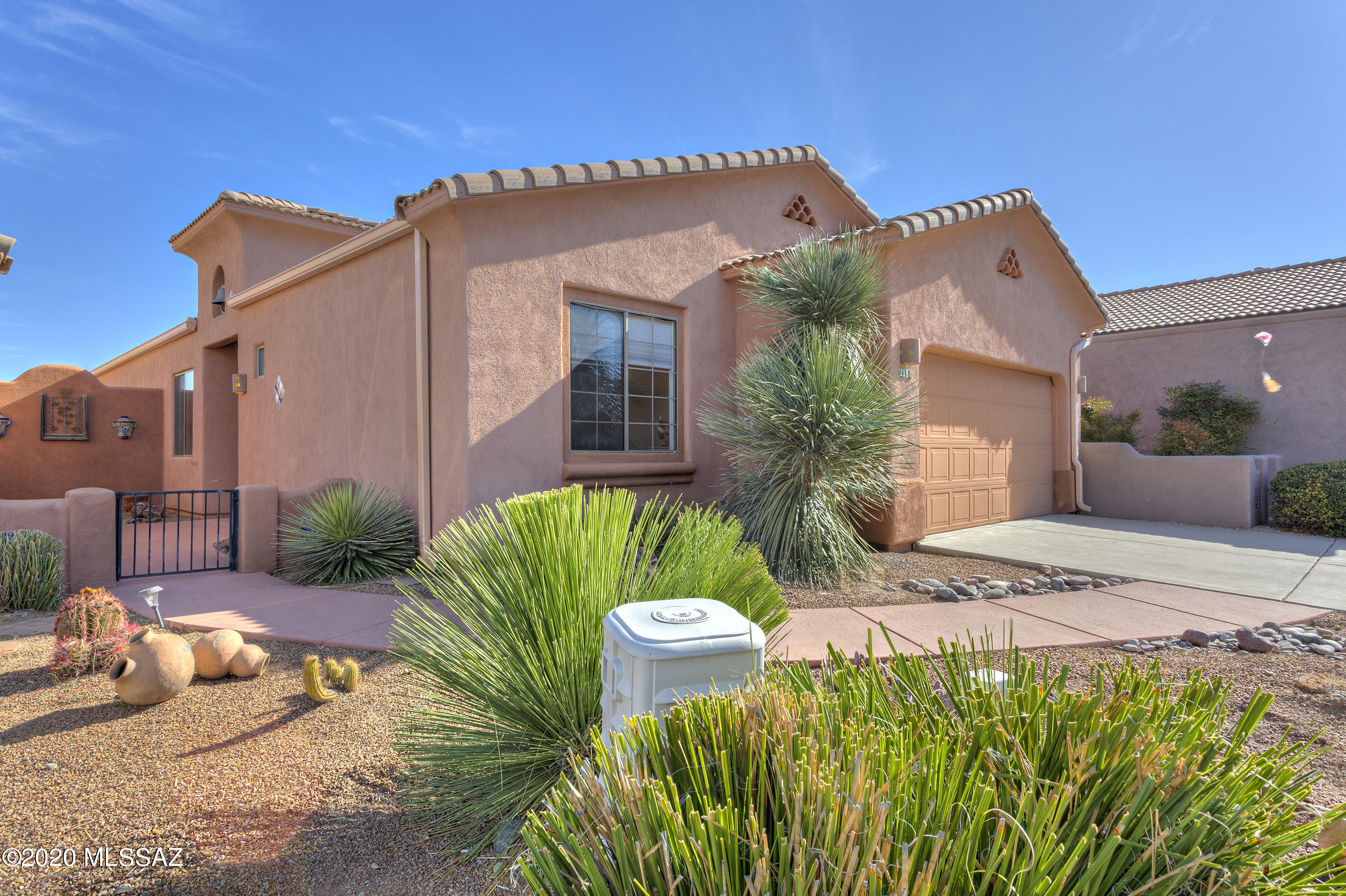 The serene entry courtyard is accentuated by the bell tower in this lovely home in the desirable Legends community. Upon entering the foyer, the posts and corbels draw you into the great room with gorgeous mountain views of the Santa Ritas. This split bedroom design is ideal when accommodating guests providing them privacy and ample quarters. Mexican tile accents the doorway into the large kitchen and provides the backsplash for the gorgeous birch cabinetry and an abundance of countertop space to have several chefs in the room at the same time. The wooden beams and space above the cabinets draw your eye to the high ceilings. The breakfast bar keeps guests close, yet out of your way. The great room provides space for formal dining, a fireplace to warm up on those cool winter nights, Beautiful southwestern cornices with copper inlay lead the way to the large screened in porch perfect for watching the Santa Ritas turn pink. A generous sized den rounds out the living areas. The owner's suite has a large walk-in closet and bath with both a soaking tub and separate shower. The mirrors above the double vanity are framed in stunning mesquite adding texture and a sense of opulence to the room. This home is fully furnished and ready to move in. Enjoy all the amenities that Green Valley has to offer.