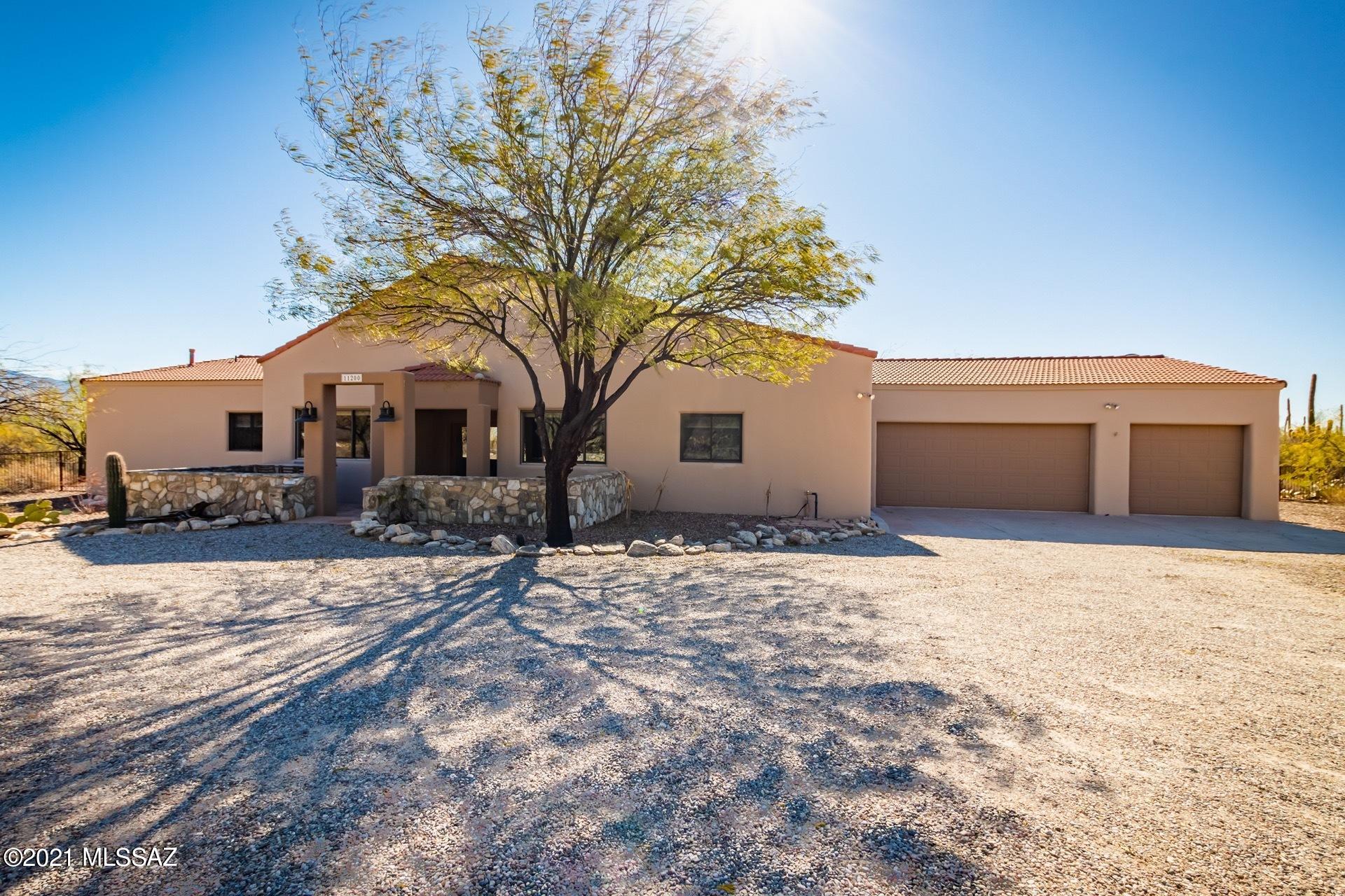 Looking for a scenic oasis in the desert with heated sparkling pool and spa, and gorgeous mountain views?   Meticulously maintained, this sanctuary is nestled on 3.3 acres among dozens of mesquite trees and Sahuaro cacti in the highly ranked Tanque Verde School District. Grounds impeccably landscaped and interior recently remodeled by Liz Ryan Design. Enjoy stunning views from the front patio or step inside to find a well-appointed retreat with character and quality throughout. Contemporary chef's kitchen features SS appliances, gas cooktop, convection wall oven, convenient island with ''command central'' breakfast bar, custom bamboo cabinets, vast counter tops, walk-in pantry with barn door entry, and coffee/study bar overlooking the serene backyard amenities galore. Kitchen and family room create a hub surrounding modern fireplace for those chilly AZ evenings, ideal for entertaining or intimate family time. Retreat to your gracious master suite with French doors providing private access to patio, pool, and spa or find solace in nearby library/office/den. Generous owner's ensuite with dual sinks, large walk-in shower, and huge custom closet. West wing boasts two additional spacious guest rooms, additional bath with walk-in shower and a powder room. Guest bedroom four off family room. Tongue & grooved ceilings in formal entry and family room, and beautiful ceramic tile flooring and classy custom window coverings throughout. Step out to the backyard and snuggle around the built-in firepit, take a dip in your sparkling heated pool, relax in the spa, or gather with friends and family to enjoy the surroundings in your outdoor dining area and kitchen with built-in BBQ. Exterior convenient pool bath completes the outdoor experience. Three car garage with 2' extension and enormous approximate 10' x 40' open hobby/craft area, workshop, or storage room. Zoned for horses, no HOA, available RV space (no electric water, or pumping station).
