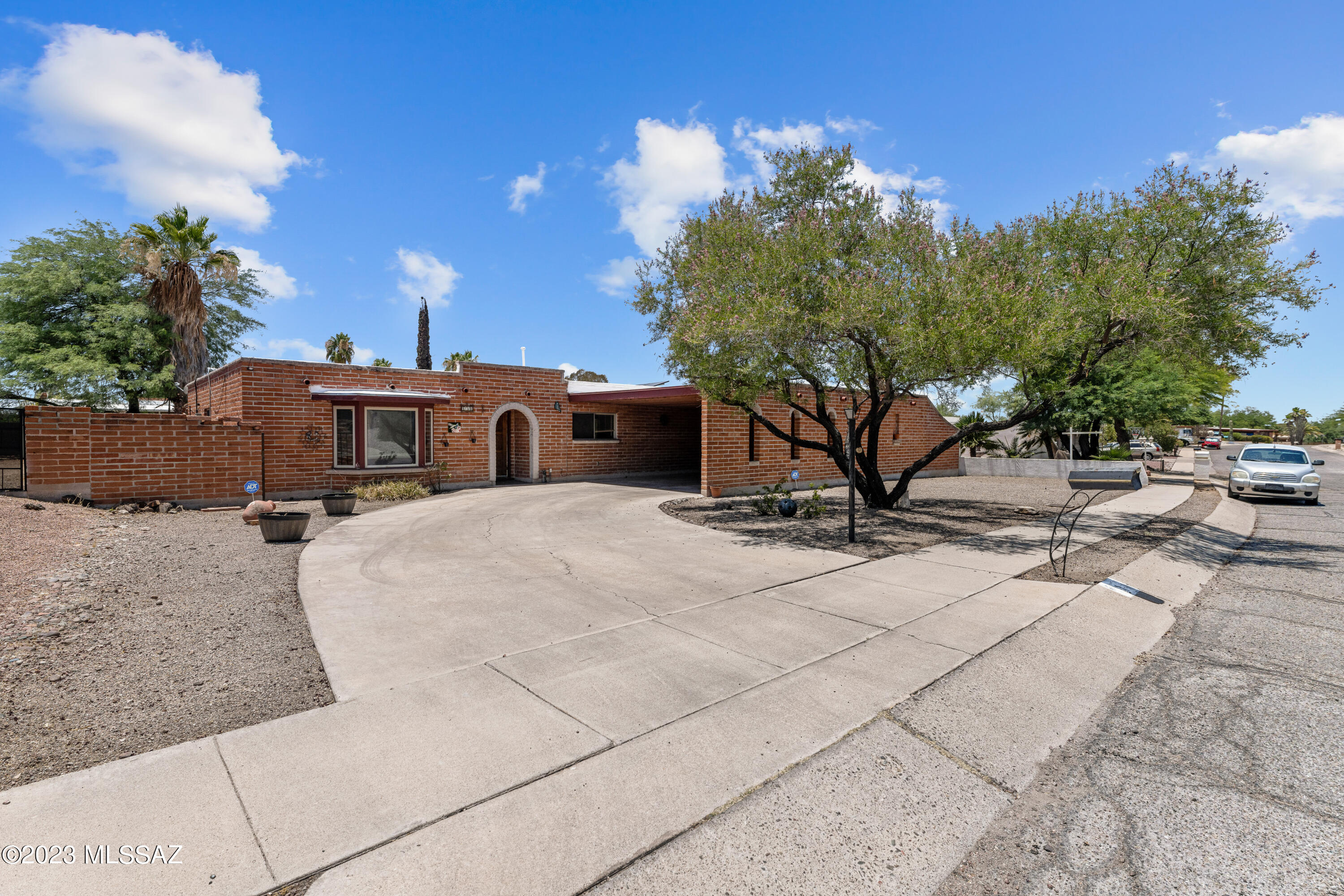 Experience Tucson's authentic charm in this 4-bedroom, 2-bathroom home. VA 2.875% which could be assumed. Constructed with beautiful burnt adobe brick, this property expertly combines traditional elements with modern conveniences. The interior offers spacious living areas. The property is accented with mature trees that add a sense of serenity to the open space. A key outdoor feature is the pool, complemented by a covered patio area - perfect for soaking up the Arizona sun or hosting get-togethers. The carport hosts an entire attached workshop, ready to be altered into a charming Casita. Schedule a Private Showing Today! Property has Solar Panels with Solar Loan that must be assumed with sale.