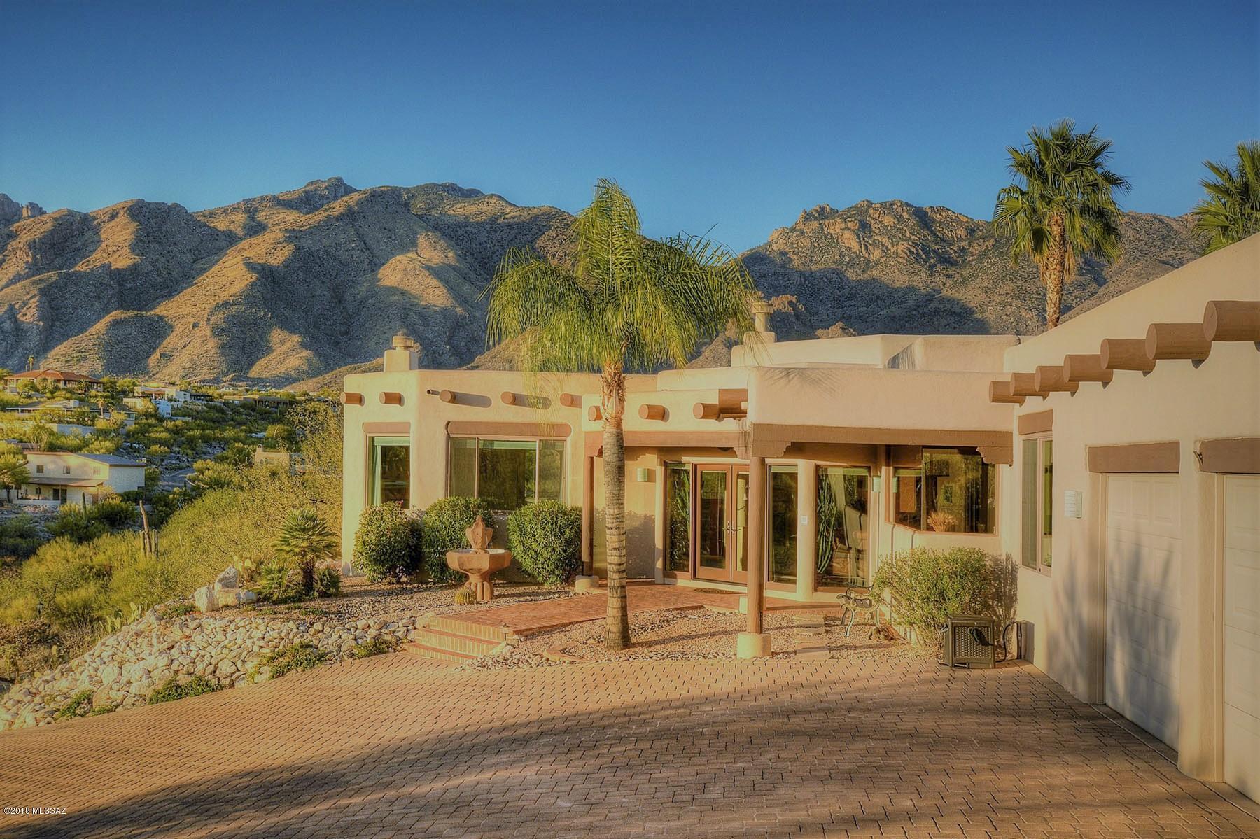 Traditional southwest home on a premium elevated lot located in Cimarron Foothills Estates. Enjoy city lights from the welcoming courtyard & mtn vistas from the sparkling pool/spa & waterfall area. This well maintained 4 BR + den & GH has been remodeled thru-out while leaving the authenticity of its southwestern charm. Flexible floor plan offers spacious living rm, family rm w/FP & walls of windows to capture the views. Kitchen has pine cabinets, newer appl & eat-in area. Master suite w/newly tiled shower, spa tub & majestic city views! Updated features include new tile, Anderson doors & windows, exterior paint, fixtures, refurbished vega beams & new paver driveway! Lush landscape surrounds the walk way to the 605 sqft guest house which boasts living/kitchenette, BR & private covered porch