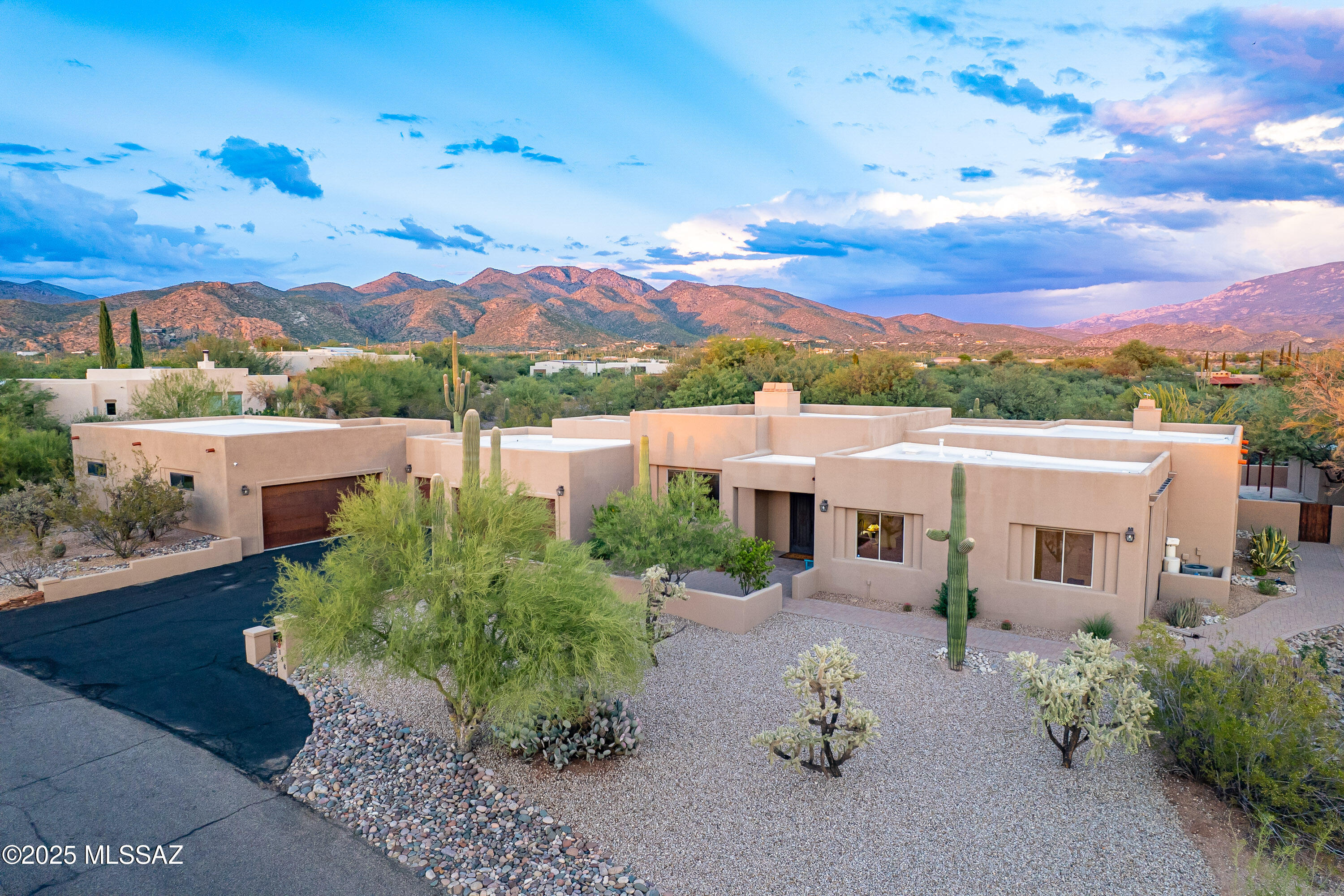 Nestled in the scenic Tanque Verde Valley, this elegant 4-bedroom, 2.5-bath home offers a perfect balance of luxury & comfort. Located in the sought-after Tanque Verde School District, it features high ceilings, spacious rooms, & large windows that flood the home with natural light. The resort-style backyard is ideal for entertaining, complete with a heated pool & spa, waterfall, ramada, outdoor kitchen, kiva fireplace, fire pit, & an additional shaded side yard for relaxing. The chef's kitchen includes three ovens, a gas cooktop, wine refrigerator, granite countertops, and knotty alder cabinets. Enjoy mountain views, stunning sunsets, & the warmth of 4 fireplaces. Additionally enjoy the three-car garage & a four-car tandem garage/workshop which offer abundant space & storage.