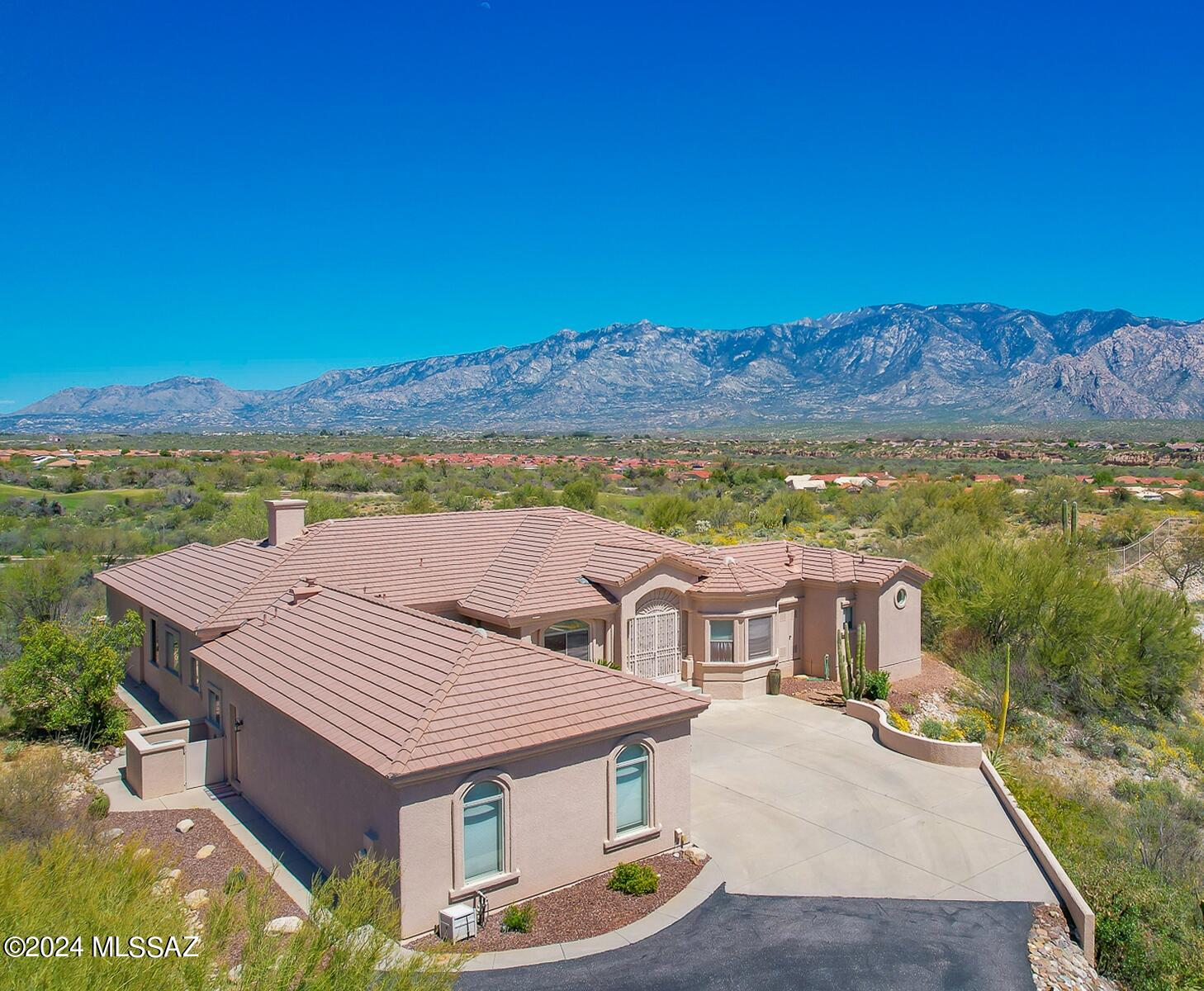 CUSTOM GATED RIDGETOP ESTATE is situated on almost an acre boasting East facing views, relaxing spool, updated kitchen/primary bath and architectural detail. This 3BD/3.5BA +Den (3,339 sq ft) home offers formal/informal living, dual en-suites, soaring ceilings, bay windows, indoor/outdoor speakers. Newer ceramic plank tile in main living areas. Great room hosts media wall w/FP and chef's kitchen w/center island, breakfast bar/nook, SS appls, quartz counters. Elegant Owner's suite affords a luxury bath w/quartz-top vanities, tiled walk-in shower, dual walk-in closets. Relax/entertain on a covered rear patio w/gas FP & BBQ plus heated, saltwater spool w/waterfall, putting green & panoramic views. Added security features, zoned HVAC/water heaters, ext. 3-car garage. A true gem in the desert!