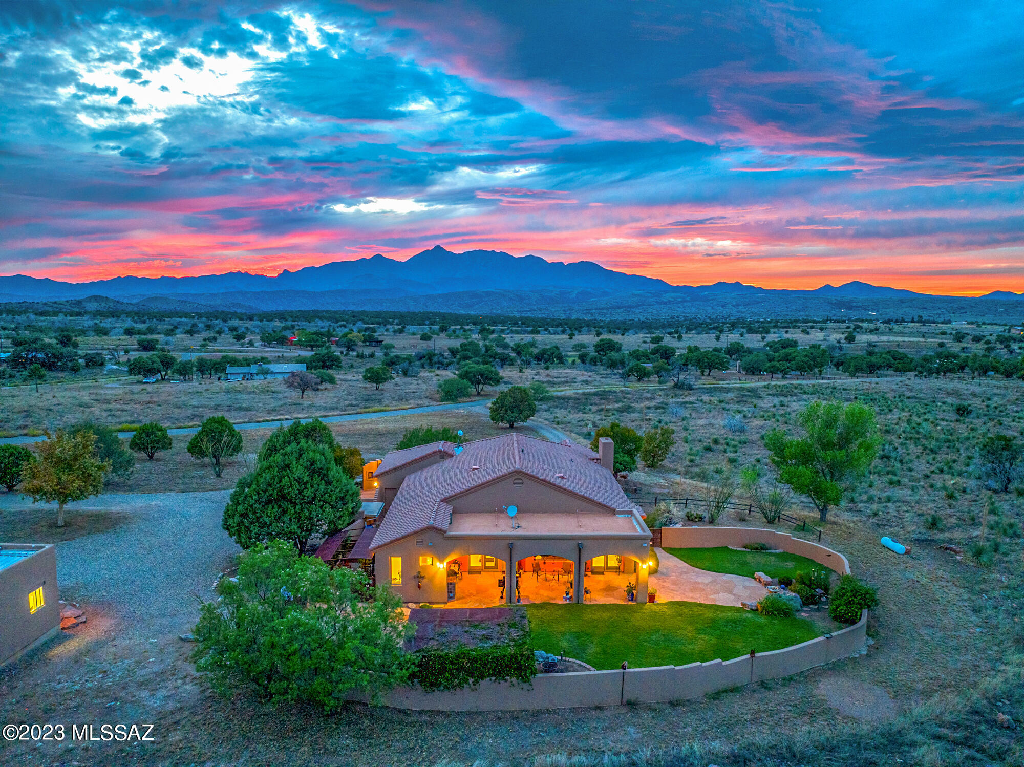 Experience breathtaking 270-degree views of six mountain ranges and the picturesque Sonoita valley. With three spacious bedrooms plus a convenient office with built-in desk and cabinets, this home offers both comfort and functionality.

The main bathroom features a large cedar-lined walk-in closet, sit-down vanity, dual sinks, and a lavish walk-in shower with bench and dual shower heads. The upgraded kitchen is complete with roll-out cabinets, spacious pantry cabinets, a wine fridge, and space for a cozy dining nook.

Vaulted ceilings grace the kitchen/family room and living/dining room, enhancing the sense of openness, while a fireplace adds warmth and charm. The laundry room is equipped with granite countertops, a utility sink, and room for an extra fridge. The two-car garage features built-in cabinets for added convenience.

The enclosed side yard offers shelving and a shade cover, perfect for cultivating your own vegetable garden. In the back yard, you'll find a deep patio with two ceiling fans, built-in grill, mature landscaping, a soothing fountain, and a vine-covered gazebo that creates a vibrant oasis.

This property has a private well, plus versatile outbuildings including a spacious workshop, storage shed, workroom, and a charming garden shed.

Don't miss the chance to make this exceptional property yours!