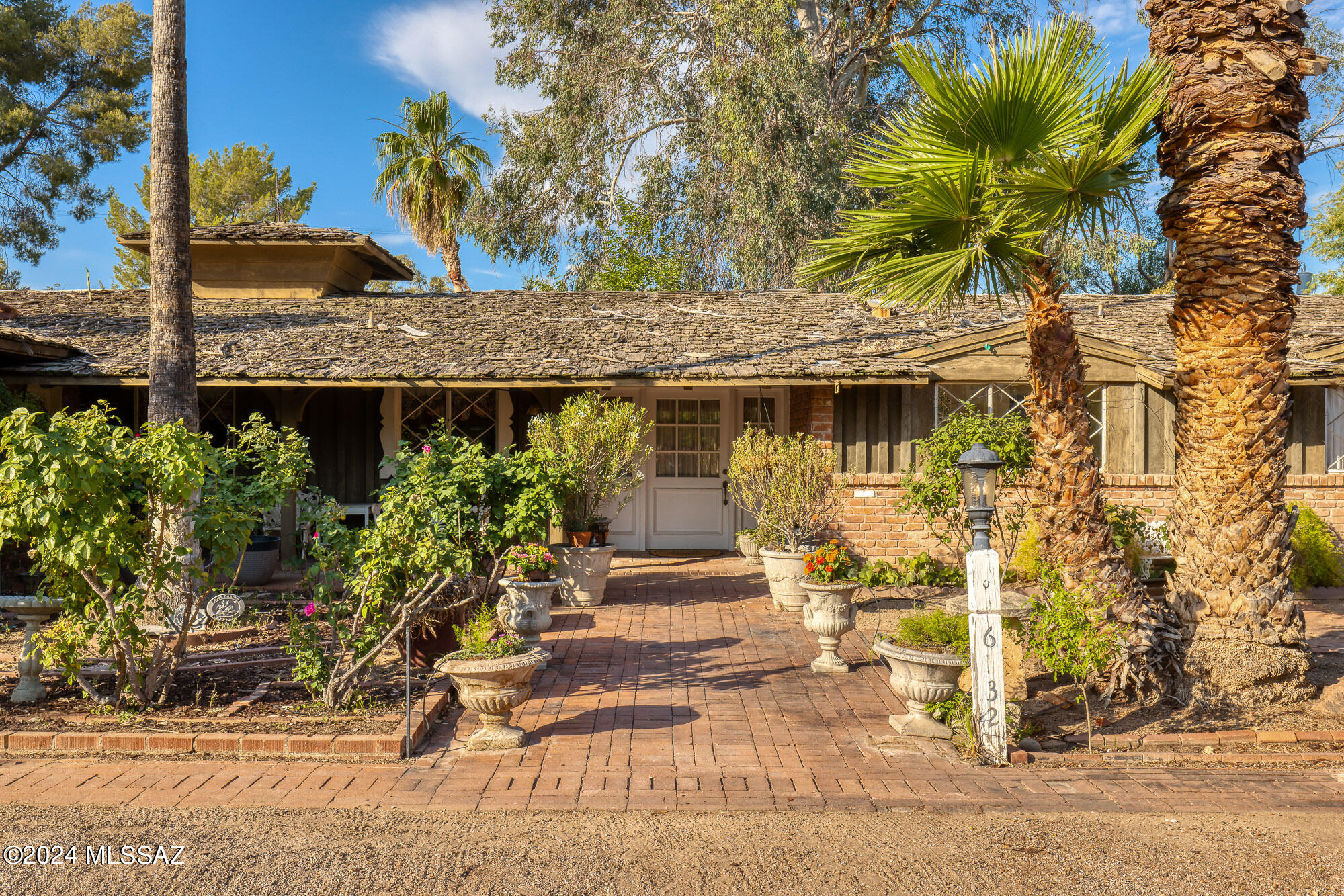Welcome to 6532 E Miramar Drive, an enchanting residence that has been cherished by two families since its construction in 1957. Built by Phil May, this home is a wonderful example of California Provincial, or Storybook architecture, known for its playfulness, whimsy, and timeless charm. Experience the allure of rough wood beamed ceilings, inviting brick walls, and soft neutral colors that create a warm and inviting ambiance throughout the home. This 3-bedroom, 4-bathroom home offers generous living spaces, including a vaulted living room with magnificent wood beamed ceilings that greet you as you enter through the foyer and rose garden. The open plan design allows for an abundance of natural daylight, enhancing the home's bright and airy feel. The home remains in its original state, preserving the home's authentic mid-century character - marble, brass, wood and colored tiles that reflect the homes period finishes.
Nestled on just under 3/4 of an acre, the property features a vast, tree-covered lot with the original pool designed by Whitaker Pools, perfect for relaxing and entertaining. Additionally, there is an attached guest quarters with a separate entrance, ideal for visitors or extended family. Practical amenities include a separate 2-car carport and storage area, providing ample space for vehicles and additional storage needs.
Located in the prestigious Tucson Country Club Estates, on one of the prime lots in the Estates, this home offers a unique blend of historical charm and modern potential. Whether you are captivated by its period details or envision updating it to suit contemporary tastes, this home is a rare gem waiting to be discovered. This is an as-is sale, and we are seeking the proper steward to become the next caretaker of this remarkable property.
Don't miss this once-in-a-lifetime opportunity to own a piece of architectural history. Schedule your private tour today and step into a world of enchantment and elegance.