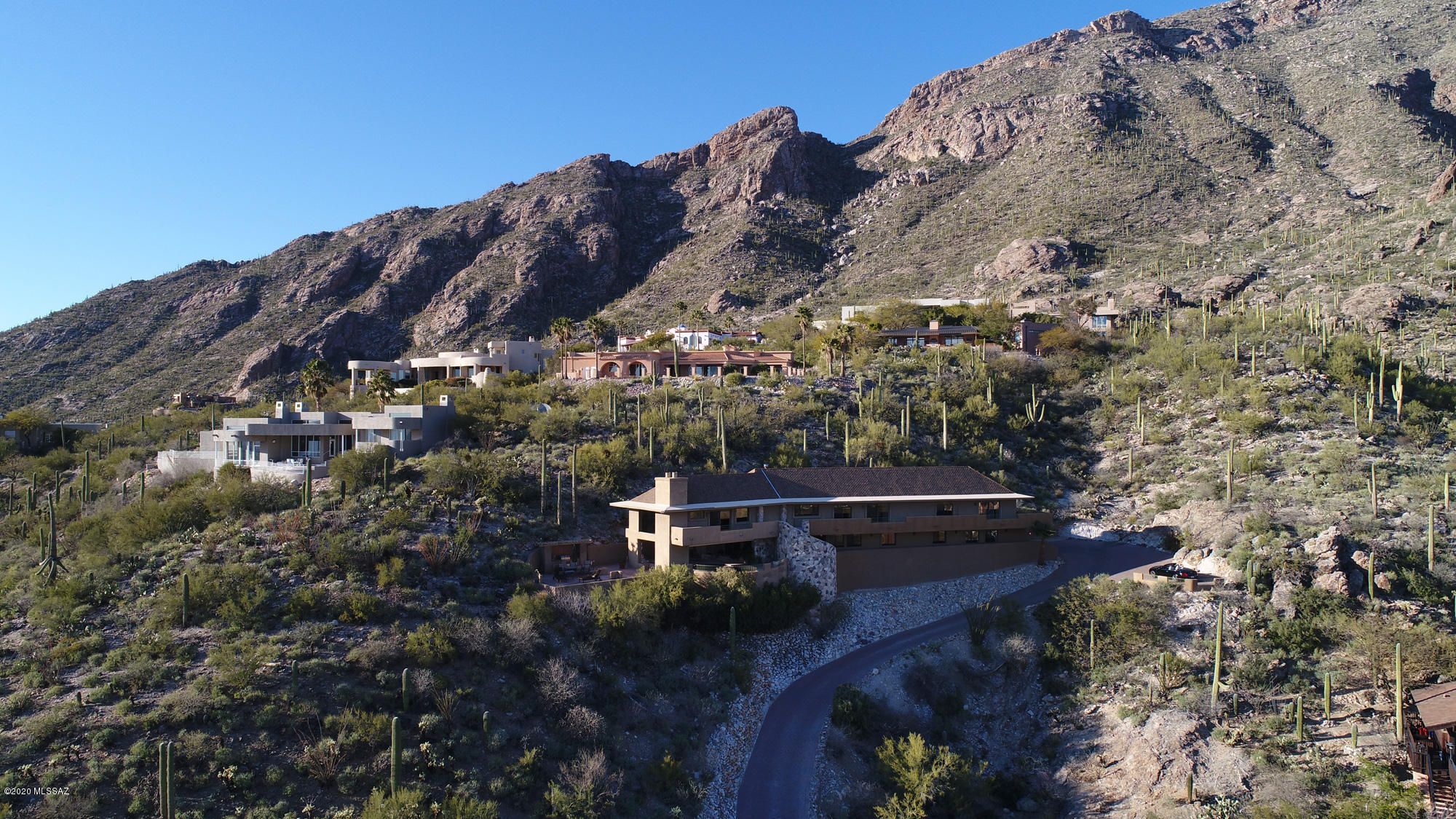 WOW!! An elegantly re-created luxurious home in guard-gated Skyline Country Club Estates, at the tippy-top of Tucson's famed Catalina Foothills (3000'+ above sea level), with dynamic wrap-around views of the many layers of mountain ranges surrounding Tucson, is now available to discerning buyers. It's been taken down to the studs and is ''new'' inside and out, from plumbing & wiring to every visible gorgeous detail. A terrace sweeps around the entire exterior providing unstoppable views. The property borders the Coronado National Forest and is fabulously secluded and private. The style is elegant but not ''fussy'', gracious yet comfortable and livable. Yes, there are stairs, but they are broad and gentle. Windows throughout are large, with many sliding glass doors out to the terrace, capturing and showcasing the fabulous views, Colors are richly neutral and all materials- travertine flooring, elegant faucets, beautiful light fixtures, high end appliances, artisan-painted walls in powder rooms-are excellent quality and tastefully selected. The quiet secluded master retreat opens to a private flagstone patio looking up to the tops of the Foothills, no homes above and not a sound except the birds and the breeze. The master bath is spacious, with a jetted tub with travertine surround, with views of the East/Southeast mountains. Separate sink areas include a make-up counter. The separate WC includes a bidet . The walk-in closet is well-appointed with shelving and handsome cabinetry. The laundry is nearby, with nearly-new LG washer/dryer and a bronze/iron (?) utility sink. A nearby guest room also opens to the terrace and enjoys an elegant bath with jetted tub/shower. Sinks are set into a granite-topped antique style chest.A warm inviting kitchen is well-equipped, with a substantial granite topped island seating four comfortable, and what a fantastic work space! Two Bosch dishwashers, glorious views for the human dishwasher, side-by-side Sub Zero fridge/freezer, a Fisher-Paykel 5-burner cooktop, two GE Profile ovens, Vinoble Wine fridge and lots of beautiful custom cabinetry complete the fabulous kitchen. A charming powder room with artisan-painted walls is nearby. The dining and living rooms have stunning forever views and a handsome gas fireplace; you can literally see down to Mexico through a grand floor-to-ceiling window. A cozy family room features a rich granite-topped bar area with refrigerator, ice maker and microwave. Beyond the sliding glass doors is a fabulous area for relaxing and entertaining, with a covered Pebble-Tec pool, surrounded by flagstone decking, another handsome gas fireplace with TV above, The nearby outdoor kitchen features a large BBQ, sink & storage. Sitting on chaise lounges on the open terrace and looking at the many mountain ranges surrounding Tucson, not to mention the city lights in the evening, is akin to being on top of the world, a truly outstanding experience. What a way to enjoy our vibrant Southwestern sunsets! A powder r oom is nearby, and back inside yet another powder room has more artisan-created wall texturing and a handsome limestone sink set in richly hued granite. An office/bedroom is nearby. Two additional bedrooms share another full bath.This lovely home has easy access to all of the many amenities of the Skyline Country Club including dining, golf, swimming and community gatherings. Located in the Catalina Foothills, with District 16 schools and many top-notch options for dining, shopping, and entertainment, and just waiting for its new owners. Please call for a private viewing appointment.