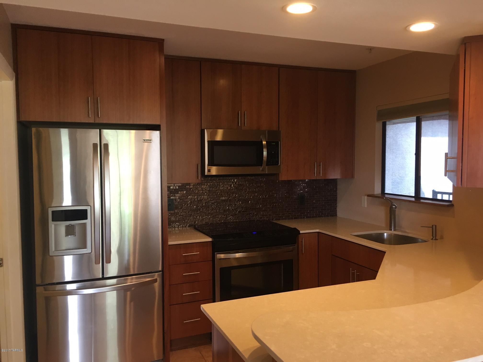 The attention to every detail makes this property the best in the community. Sitting in building 17, this condo is nestled in the back of the community with sweeping views in every room of the Rincon and Catalina Mountains. Special features include Thomasville self closing cheery cabinets, Silestone counters, artistic glass backsplash in kitchen, Kenmore Stainless appliances, Top bottom/bottom top blinds, waterfall shower, designer lighting fixtures, wood laminate floors in bedrooms, ample storage with walk in closets and patio closet, front loader washer/dryer, condo has been completely replaced kitchen, master bedroom, flooring, water heater, and AC on rooftop. The community is gated and conveniently located at Kolb and Sunrise