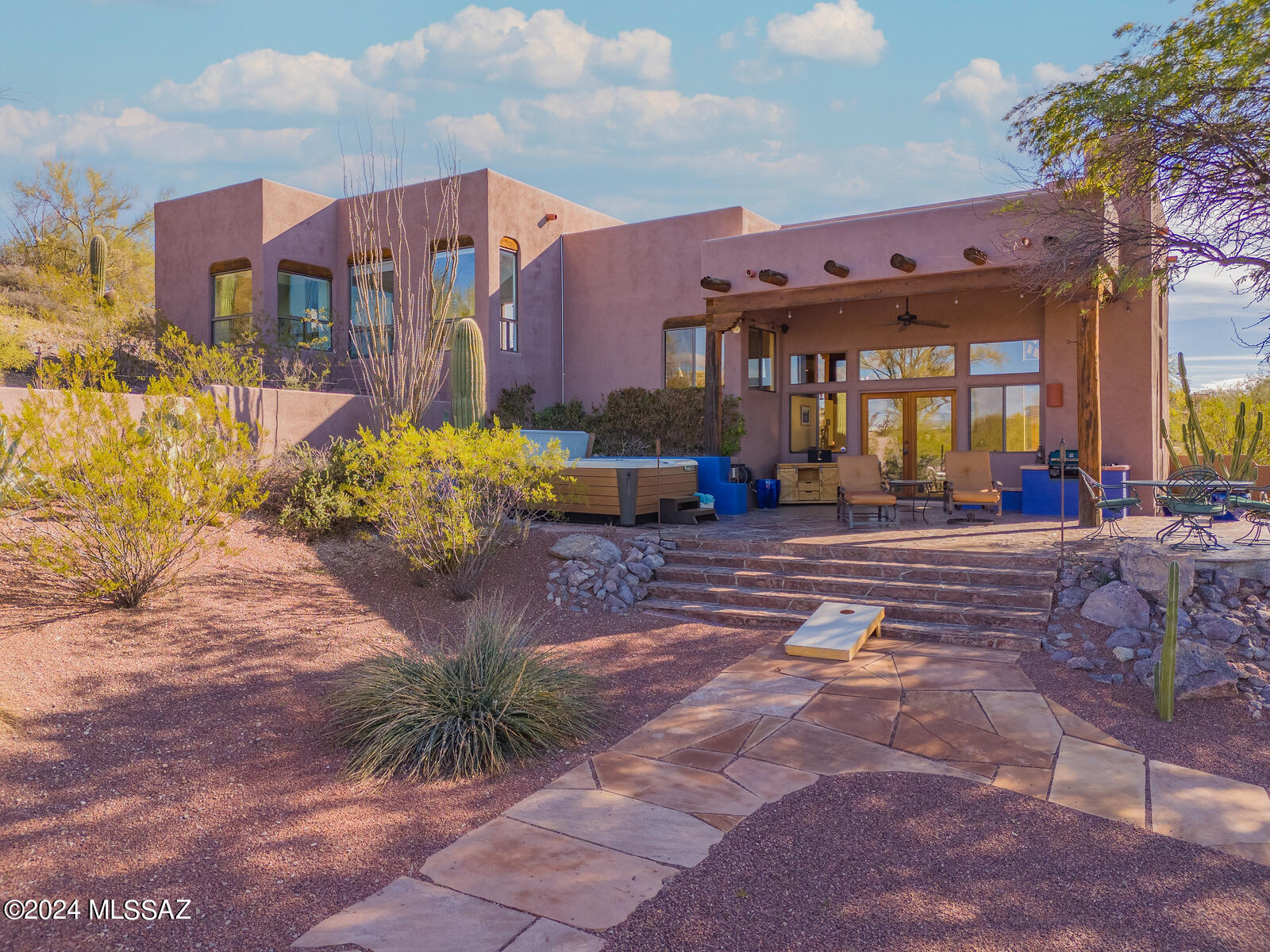 Contemporary Multi-Level Santa Fe with Southwest accents throughout this custom home. It is  sited on a 1.13 acre cul de sac lot with panoramic vistas. the dramatic great room has soaring viga ceiling, concrete floors, modified beehive gas log fireplace  and clerestory windows to capture the panoramic views and create a light and bright feel. Saltillo tiles throughout the rest of the home.  Wood doors and cabintry with Saguaro rib accents add to the Santa Fe feel. Talavera tiled countertops and niches add a warm sw touch.  Jenn-air appliances for gourmet chef. . Mountain & City Light Views. French doors to covered patio; walled yd, natural gas grill. Several sahuaros & trees in walled yard add privacy for enjoying your desk side hot tub.