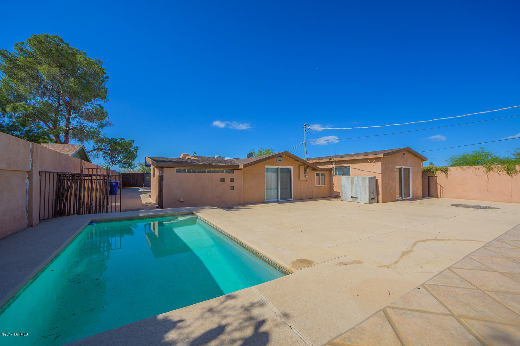 Private gated home near U of A with sparkling swimming pool! Built-in outdoor BBQ and storage shed (with electric outlets).  Tons of parking space! Home has been professionally cleaned. Kitchen includes new cook-top, and lots of counter space for cooking and entertaining. A cozy fireplace graces the great room. Laundry room includes washer and dryer. Spacious walk-in shower and custom cedar closet in master suite. Tiled throughout with carpet in bedrooms. Upgraded light fixtures. Low maintenance landscaping. A true paradise both inside and out!