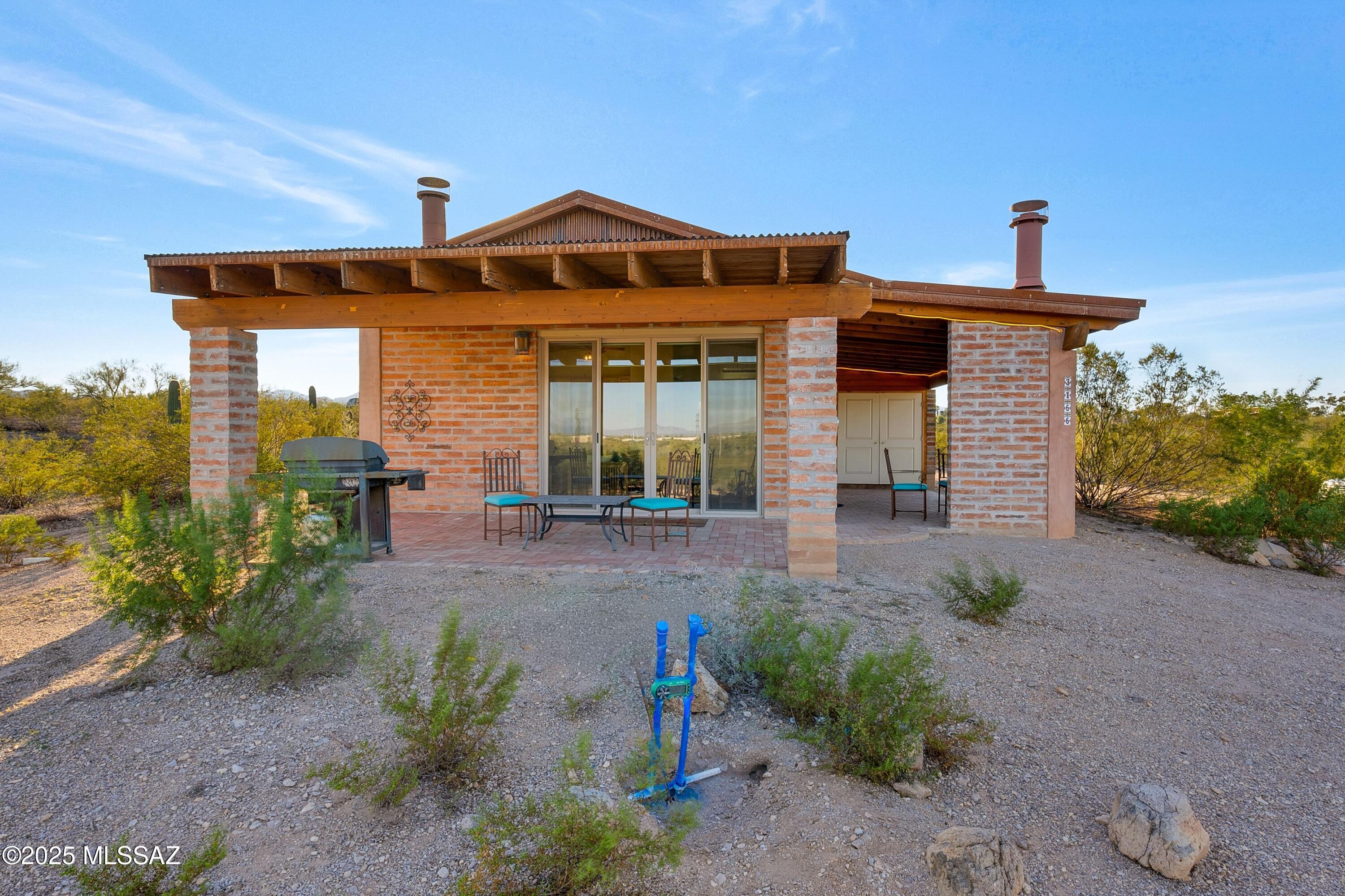 Unique, Custom & an artists creation! This darling 2022 burnt adobe home is incredibly resource efficient on 4+ acres. Huge windows bring in glorious natural light. Two custom fireplaces, the great room has a unique burnt adobe fp that circulates the heat & custom painted beehive on the patio. The views in every which direction are lovely to include the Catalinas, Rincons, Tortolitas & Tucson Mtns! Built with intention, the east, south & west walls are 4'' adobe, 2'' foam, 4'' adobe with an R Value of 13.6. The METAL roof of the home also has 1'' rigid foam, R38 insulation in attic & cedar ceilings with a total R Value of 42! Plus overhangs provide shade & have added rigid foam. 6 car carport with TWO RV hookups! Lots of space to store materials, tools, equipment, toys. Close to The Loop!