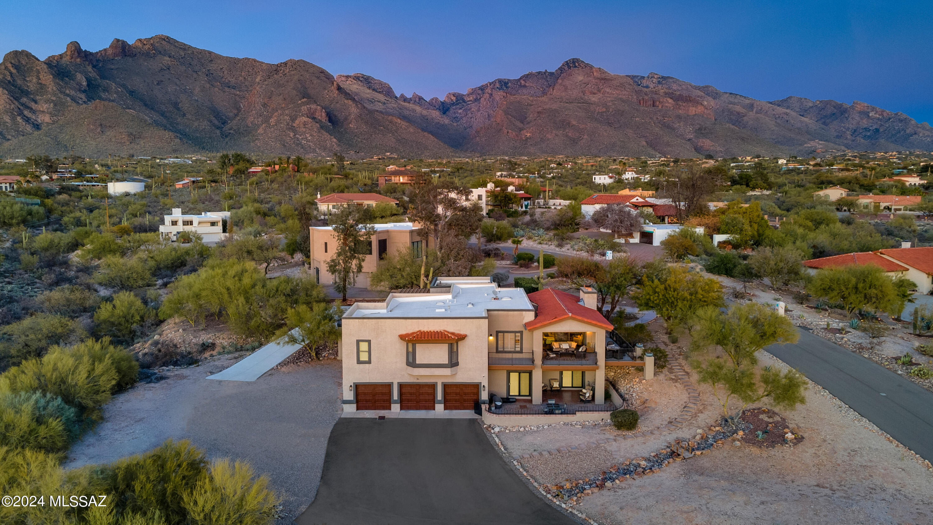 Experience the epitome of modern design harmoniously blended with the essence of Sonoran Desert living. This exceptional home offers breathtaking views of both majestic mountains and city lights, creating a unique and unparalleled living experience. The stacking glass wall off of the great room creates a vast opening that transforms the upper viewing deck into an extended living space for enjoying the spectacular sunsets and city lights. The gourmet kitchen is a masterpiece, boasting a 36-inch range, a custom beam range hood, a hammered nickel farm sink, a 64-inch built-in refrigerator, and a wall oven. Adorned with custom inset shaker cabinetry, and illuminated with thoughtful lighting, this kitchen is a culinary haven. Indulge in luxury in the master bathroom, where a white spruce sauna , custom cabinetry, wall faucets, a spacious shower (barrier-free), and a spa tub create a spa-like retreat. The first-floor master bedroom seamlessly connects to the upper viewing deck, offering a captivating night city view. The spacious laundry room is adorned with a farm sink and charming brick flooring. Solid core doors, wide doorways, two fireplaces, and a walk-out lower level enhance the home's allure. The home boasts a charming guest suite complete with a convenient kitchenette, providing a private retreat for guests. A must see! With a 4-car garage and ample space on over 1 acre of land, this residence effortlessly combines elegance and functionality. Three covered outdoor patios invite you to enjoy the surrounding beauty while soaring ceilings and abundant natural light set the stage for a truly enchanting atmosphere. Unparalleled in Tucson, this home invites you to fall in love with its unique blend of luxury, design, and desert living. Don't miss the opportunity to make this extraordinary property your own - come and experience it today!**Assumable VA Loan Option 2.25%**