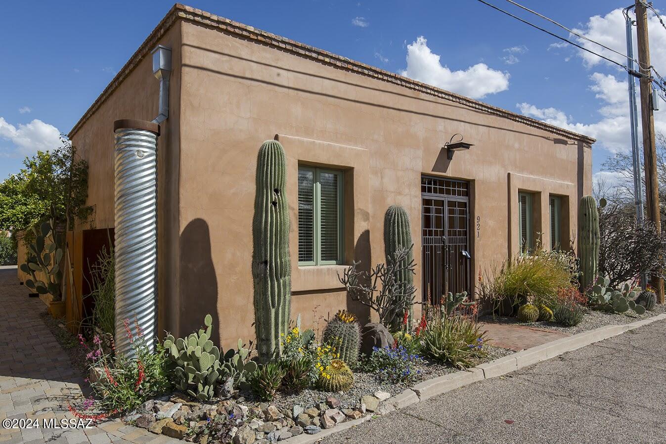 Gorgeous Barrio Santa Rosa home with all of the charm and Sonoran style of the barrios, but built in 2005.  Modern styling, high ceilings, open floor plan, lots of light!  The very definition of sanctuary, quality french doors open from almost every room into the private walled courtyard, a patio oasis. Enormous custom mesquite door, refinished hardwood floors, custom paint.  The skylight runs the entire length of the home.  Polished concrete floors in the bedrooms and guest bath, done by Rogo's.  Enormous office/den easily converts back to a 3rd bedroom, just add a modern barn door.  Enjoy the rarity of a two-car garage and laundry room with full size w/d, utility sink.  Cobbled driveway is shared with the neighbor.  This is the perfect barrio retreat!  Come take a look.