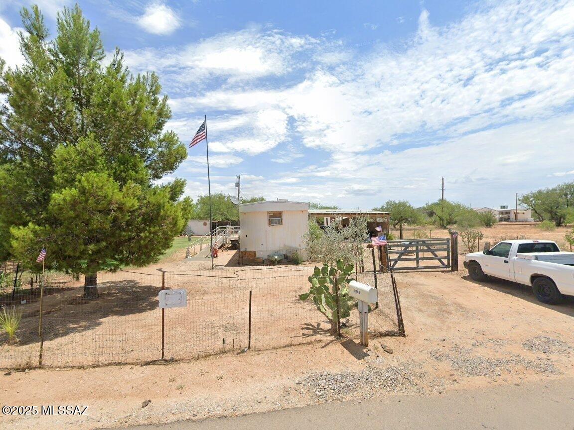 FIX-UP OPPORTUNITY SOLD AS-IS!!  This find is a diamond in the rough. Great potential with some TLC you can bring back to life nestled in the beautiful Arizona desert with gorgeous night starlit sky views. This is a 12x64 1970 year built, 3 bedrooms, 2 baths manufactured home.  Large lot completely fenced-in with double access entry at west and east wing, permitted in 2014 added a spacious carport 18x22, professionally installed wheelchair accessible metal ramp leading to main entry of the home.  City water and Paved roads maintained by Pima County.  Don't miss out! Buyer to verify all information.