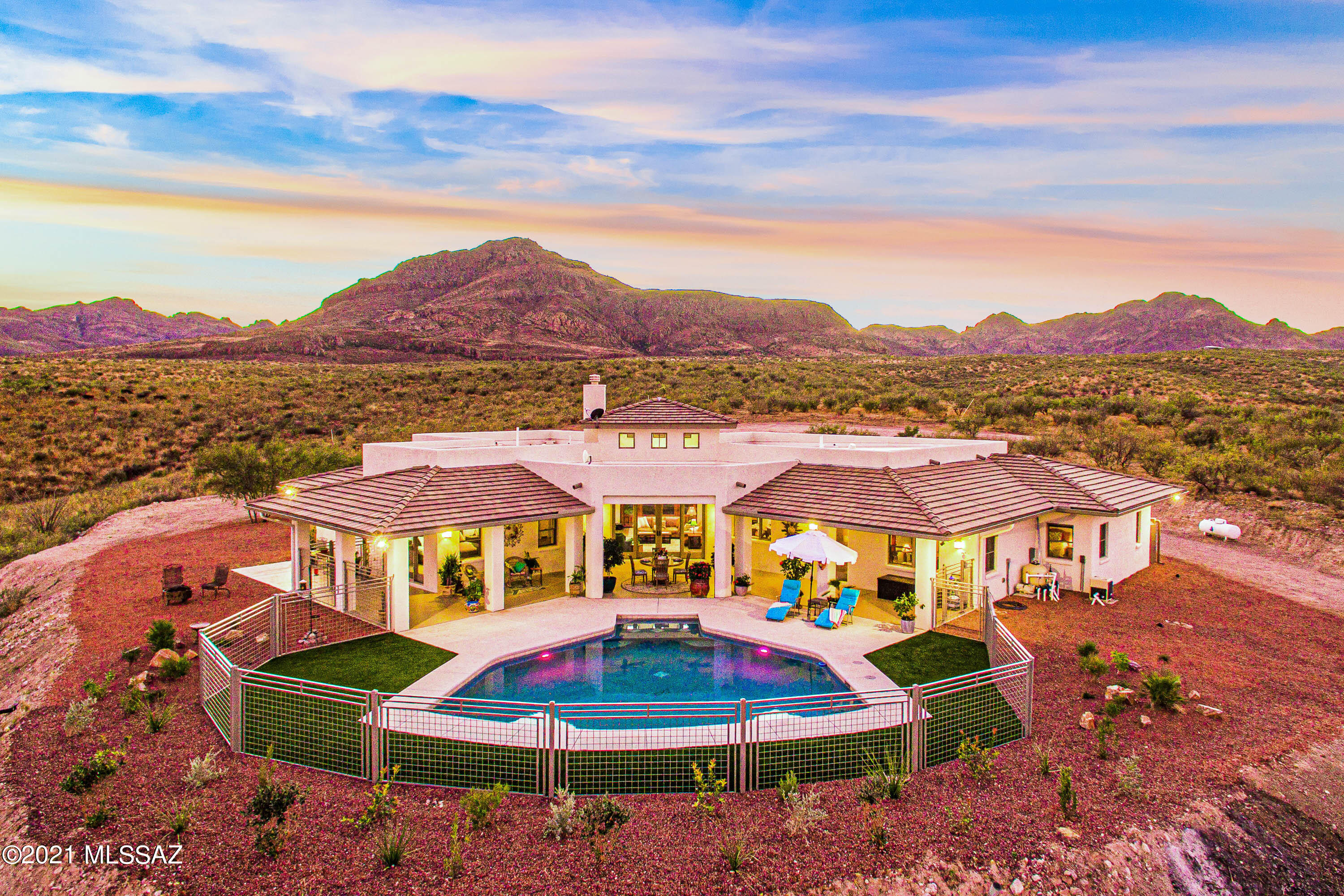 Beautifully updated & gated hilltop home with pool in Tubac. Located on over 9 acres, providing panoramic mountain views. Private and no HOA yet moments from Tubac Golf Resort and highway access. Entry courtyard with pergola and custom doors. Open floor plan, high ceilings and plenty of natural light. The kitchen offers a stainless steel 6 burner gas range and refrigerator. Modern basin sink, granite counter tops, island and cabinets. Split bedroom concept with fresh paint, new lighting fixtures and ceiling fans throughout. Primary bathroom features a new tub, tiled shower enclosure and double sink vanity. Guest and hall bathrooms are fully remodeled. Large covered patio overlooking pool with endless views. Multiple water harvesting tanks and gutters installed. Must see to appreciate!