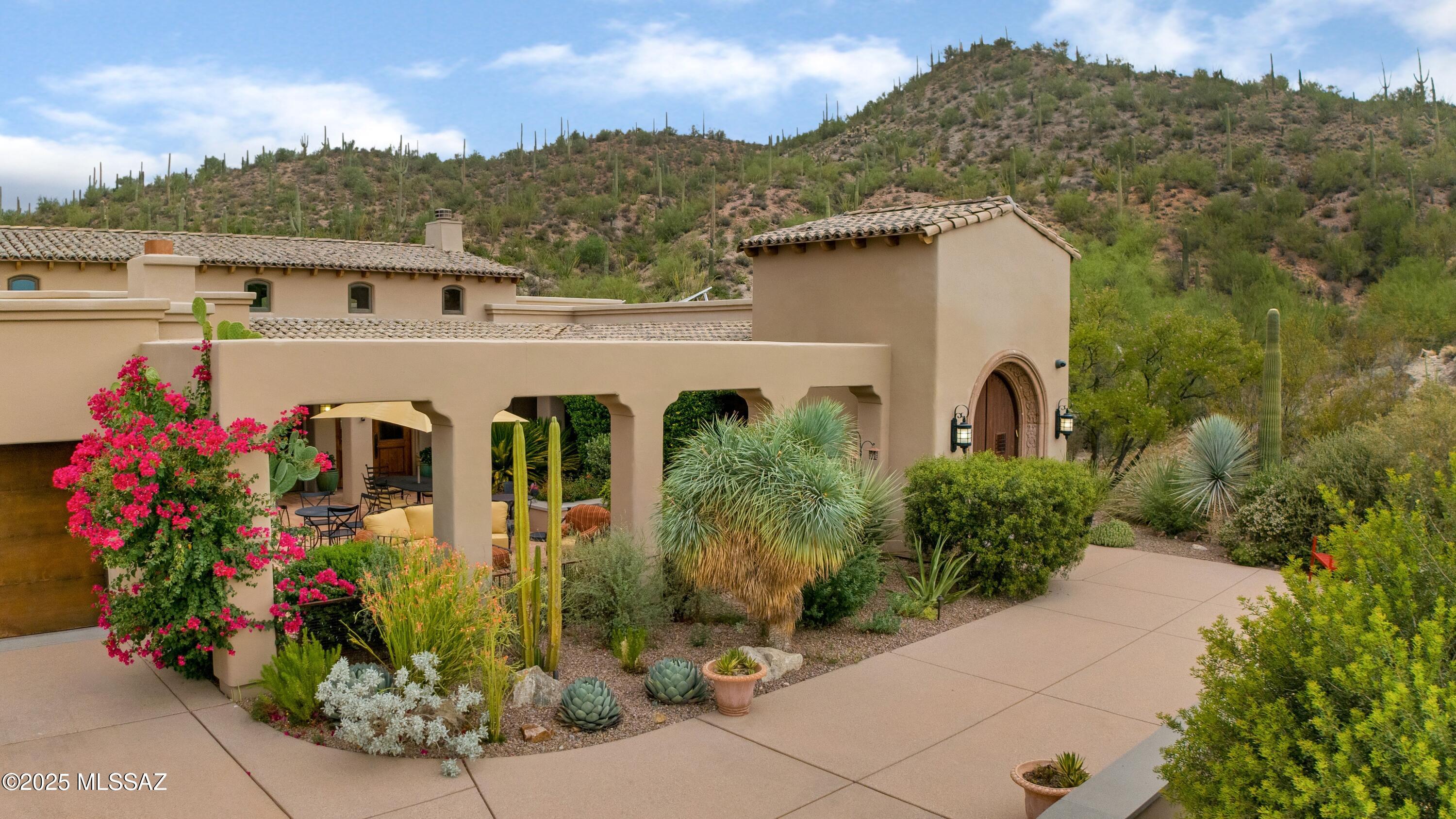 Tucked away in gated Wildcat Pass, this Hacienda-style retreat stands as one the most exquisitely crafted residences in Tucson. One of only four homes in Arizona to earn a LEED Gold Certification, this home reflects a rare commitment to environmentally conscious design and quality construction. Backing to 84 acres of pristine desert land, the home offers privacy and panoramic views of mature cacti, dramatic rock formations, and the rolling desert hills. The front courtyard is designed for effortless entertaining, complete with a custom outdoor kitchen, cozy fireplace, and elevated city views. The spacious primary suite offers the feel of a private desert resort—complete with tranquil views, spa-inspired bath, and a walk-in shower. A split floor plan offers flexibility, featuring a  (CONT beautifully appointed guest suite that ensures comfort for visitors. Thoughtful architectural elements ensure the desert is not just a view, but an integral part of daily living. Expansive, dual-paned windows flood the interiors with natural light, framing the surrounding beauty and enhancing energy performance. The open-concept kitchen and living areas flow seamlessly to the tranquil backyard, where a saltwater spa with water features invites relaxation. The grounds are masterfully landscaped with curated desert vignettes that reflect the natural beauty of the Sonoran environment. Just minutes from downtown Tucson and the hiking and biking trails of Starr Pass, this home offers peace without isolation. Every detail has been carefully considered in this one-of-a-kind sanctuary. A true celebration of craftsmanship, sustainability, and elevated desert living
