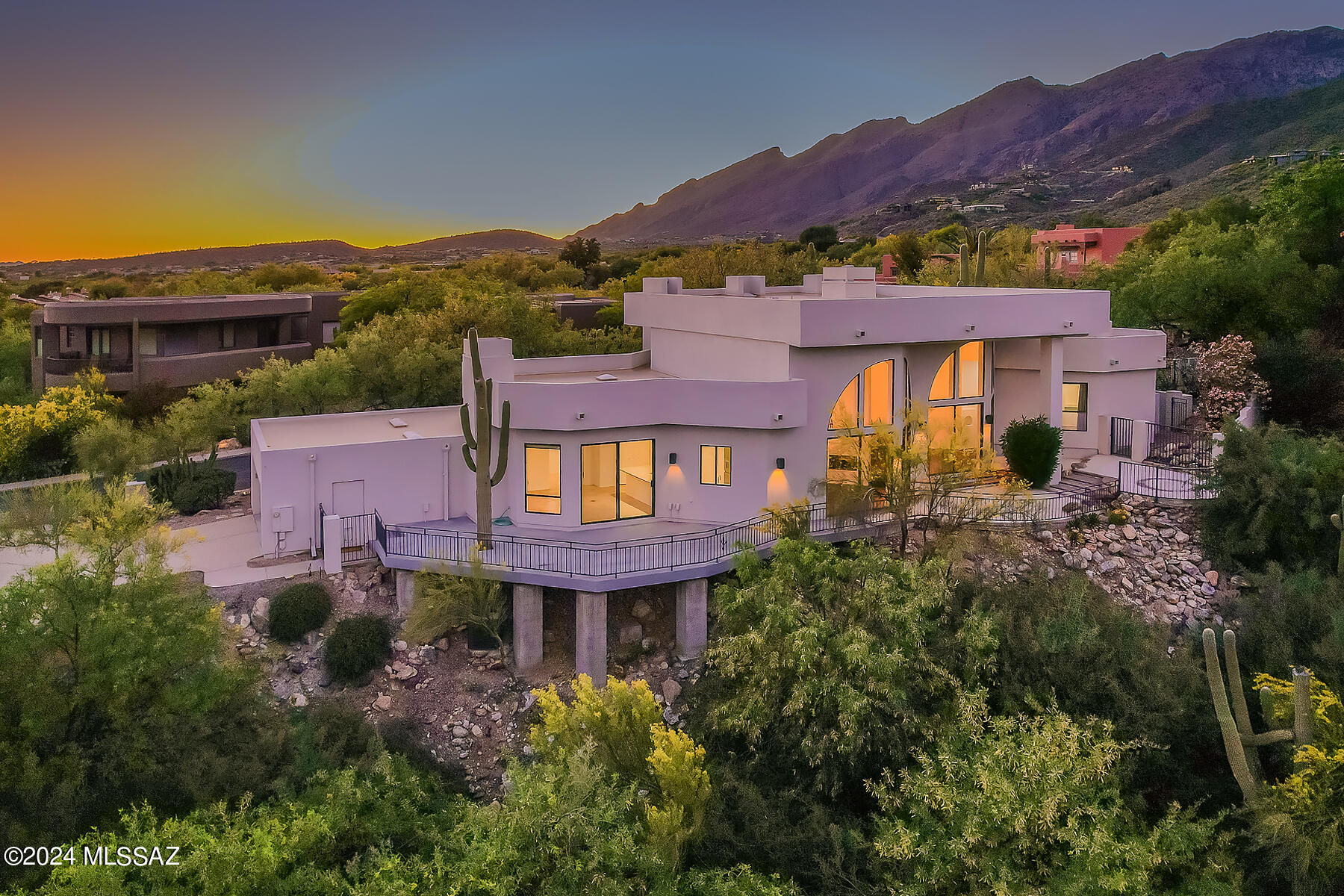 Experience elegance and modern comfort in this updated 3,049 sq. ft. residence located in the prestigious Ventana Canyon Estates. This exquisite home boasts 4 bedrooms and 3 baths, featuring wood and travertine flooring throughout, a completely remodeled kitchen with granite countertops, and updated bathrooms, all designed with impeccable taste.

Built by Bryan Martinovich, this thoughtfully designed home sits on the 3rd Fairway of the Canyon Course, offering breathtaking city and mountain views. The home showcases high ceilings, a dramatic double-sided fireplace, and walls of windows that flood the space with natural light and provide stunning mountain and city views from the expansive deck and patio. The outdoor living area is perfect for entertaining and enjoying the serene surroundings.

The spacious primary suite and a versatile den or 4th bedroom are conveniently located on the first floor. An elegant glass walkway overlooks the living and dining rooms and leads to two additional bedrooms and a bath on the second floor. The family room features a gas fireplace and opens to the kitchen, making it an ideal space for gatherings.