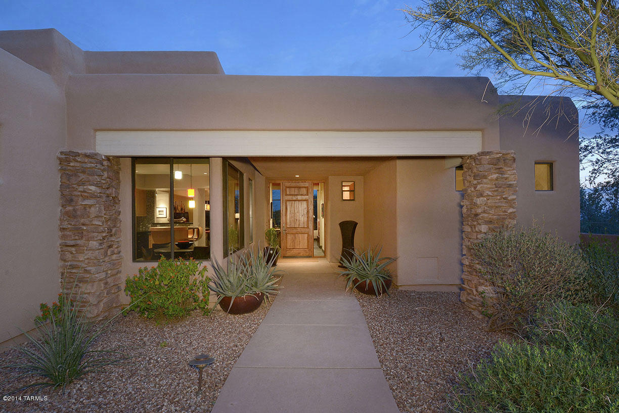 This immaculate 2 Master BR, 2 1/2 BA contemporary home is nestled at The Gallery Golf Club Cottages at Dove Mountain & offers exceptional golf course, lake & mountain views. Highlights include many upgrades & custom features, a courtyard entry, an open flowing floor plan, stacked stone accents, slate tile flooring, exquisite light fixtures, a surround sound system, & a gourmet island kitchen with granite countertops & designer stainless steel appliances. The spacious great room features a large picture window, a custom patina fireplace, a soaring beamed & planked ceiling, a wet bar with wine cooler & a formal dining area. Relax on the beautiful back patio while watching the ducks & cranes gather at the pond, or entertain by the fireplace under the porch adjacent to the lap pool & spa.