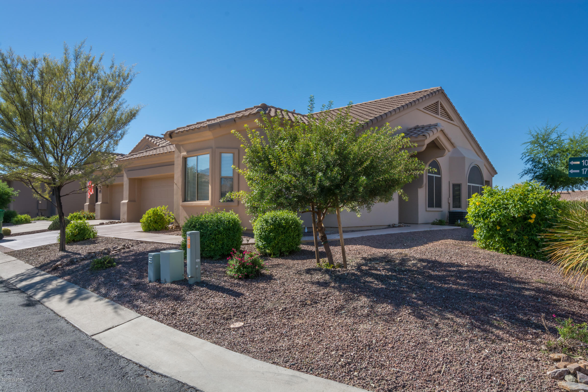 Located in gated Vistoso Village, an Active Adult Community, this well maintained Chula Vista models sits on an elevated corner lot overlooking common area. Interior features include open great room concept, vaulted ceilings, bay windows in great room, master and guest bedrooms create additional seating or work area. Kitchen amenities include stainless steel appliances, laundry room and pantry off kitchen. Garage has  built-in storage cabinets, utility sink, work bench area & epoxy flooring.  Extended brick paver patio and BBQ niche provided the perfect space for outside enjoyment.  Sunrise to Sunset this  light & bright home is very Welcome Home! HOA fees include:  water, trash, sewer, basic cable, front yard maintenance, pest control, roof, structural insurance, exterior paint .