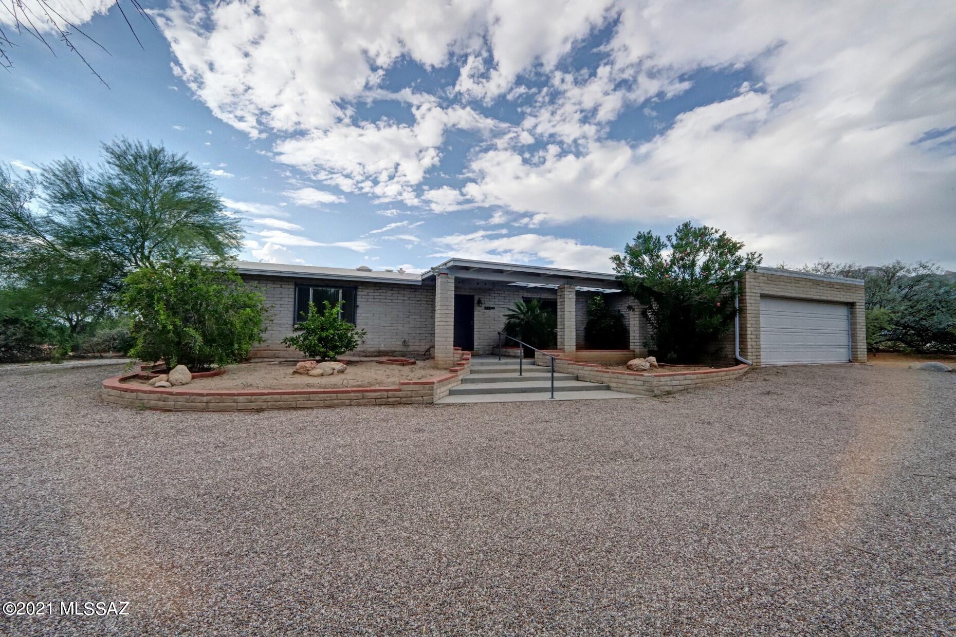 Oh, the convenience this location has!  Close commute to U of A, downtown, bus lines, shopping, excellent schools, & fine dining!  This lot offers fantastic mountain and sunset views from your backyard pool area.  Lots of hardscape for entertaining & room  for an outdoor kitchen, etc.  The lot is almost a full acre bordered by a wash behind for lots of privacy. The inside offers an updated kitchen with lots of storage and cabinetry. A separate family room provides a large wood-burning fireplace with a nice hearth for the holiday gatherings.  No popcorn in this home, newer tile in most areas. This home will offer comfort & convenience  for anyone seeking the Foothills for their new neighborhood.