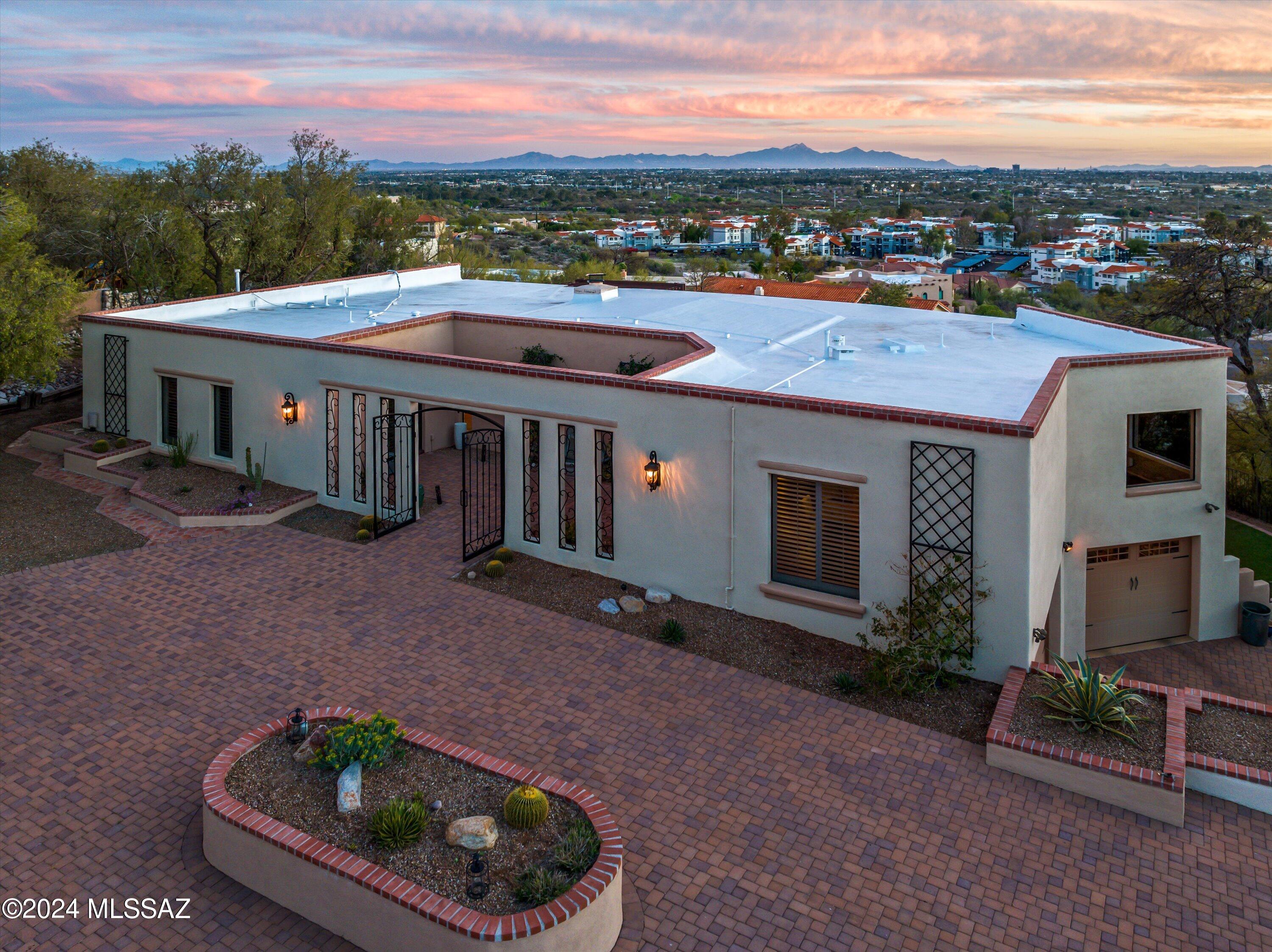 BUYER'S FINANCING FELL THROUGH! Catalina Foothills property on elevated lot with unobstructed city and Mountain views! Eye catching curb appeal with brick paver circular drive way and gated private courtyard entry. Bright and spacious great room with soaring exposed beam ceilings, fireplace, and a picturesque wall of windows over looking the city of Tucson. Huge primary suite with beautiful bathroom and large walk in closet. Updated Kitchen with quartz countertops and stainless appliances! Entertainers delight with Multi-level panoramic covered view decks with twinkling city lights and color changing mountain views. New Roof! Must see!