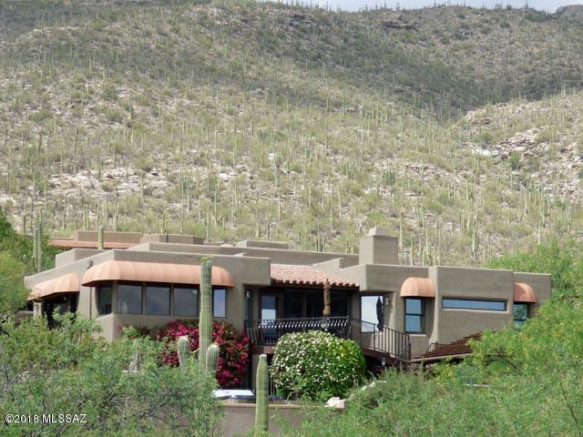 The kitchen is the heart of the home and this home has a beautiful heart with spacious granite counters, knotty alder cabinets, travertine floors, SS appliances, two breakfast bars (one high, one low), and panoramic views which extend far beyond the Tanque Verde Valley. From the moment you enter this home through custom mahogany doors with art glass into the large living room with soaring ceilings, you see and feel the elegance, the grandeur, the generous bonhomie of desert living at its finest. Artistic touches, custom designs, and high-end finishes are evident everywhere you look: iron scrollwork, Mexican tile, ornamental cornices, Roman shades, sheerweave screens, poolside pergola, rolling shutters, et alia. Guest quarters with private entrance. The list goes on. Welcome home!