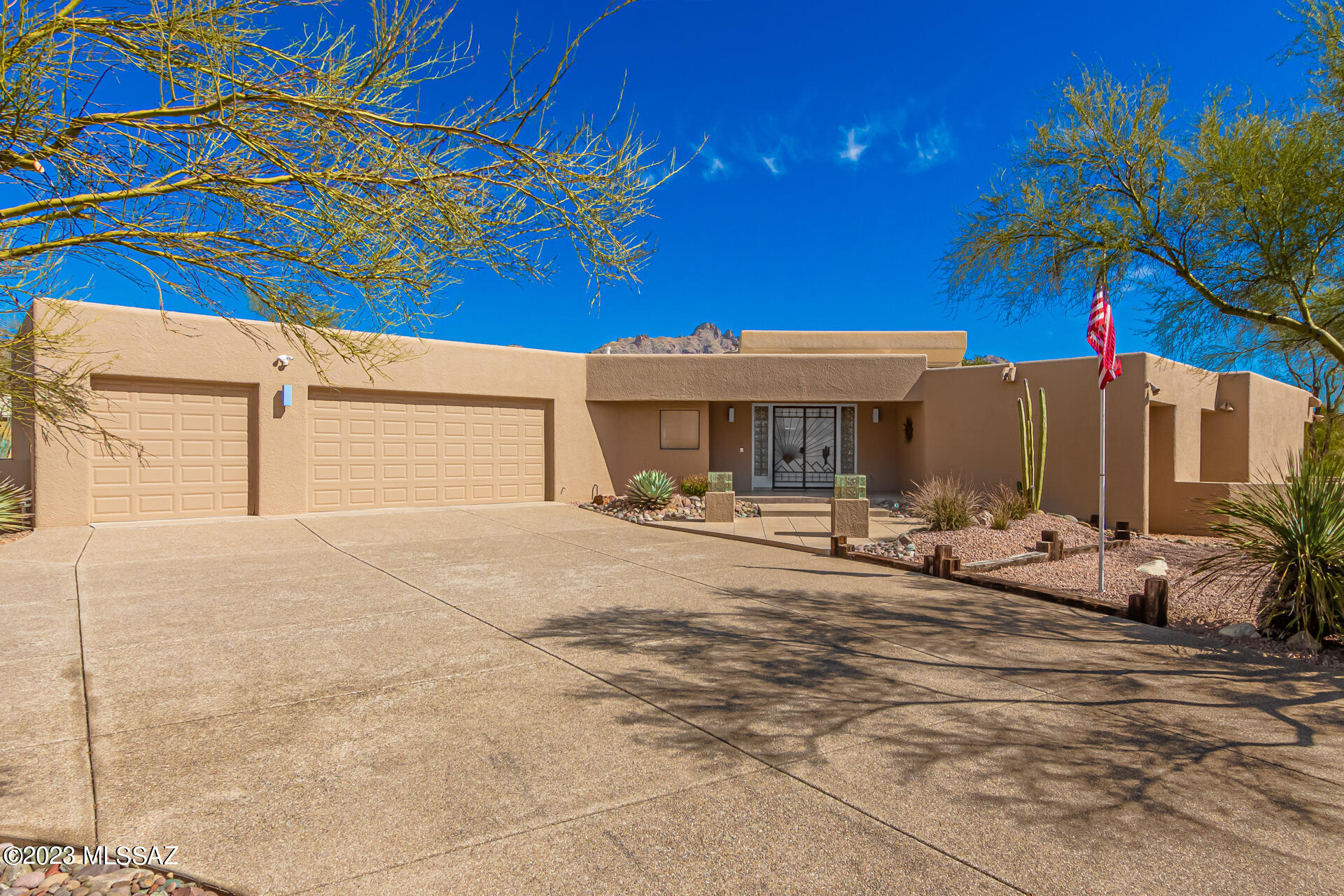 Lovely contemporary home in the heart of Shadow Hills offering panoramic mountain views, beautiful natural desert surroundings, and privacy with plenty of space! 
The double door entry welcomes you into the foyer and light-filled great room with exposed wood beam cathedral ceilings, a Wells Furnace Fireplace, built-in cabinets, and views of the backyard oasis and the Catalina Mountains. 
This is an ideal place to entertain friends or to relax and unwind while enjoying the Catalinas splendidly change colors with the setting sun! 
Office/den with extensive built-ins and more incredible mountain views. Double doors leading to the great room allow you to leave work behind at the end of the day. 
This property features two oversized Primary suites in a split bedroom plan, and 3 full bathrooms.
Primary suite 1 has a luxurious ensuite with built-in cabinets, dual sinks, and opens to a private deck equipped with a relaxing hot tub to help unwind at the end of a busy day.
Primary suite 2 with an adjacent bathroom is a perfect guest quarters or mother-in-law suite.
Huge Bedroom 3 offers a wall of closets and an adjacent bathroom.
All bedroom closets complete with custom built-in cabinetry. 
Chef's delight kitchen has it all: spacious Corian countertops; loads of cabinets, trash compactor, convenient breakfast bar, and large walk-in pantry. All appliances convey. 
Other extras include: Zoned AC/Heat; Solar Water Heater, extended-length 3 car garage with built-in cabinets, overhead shelf for extra storage, and lush front and back yards with plantings and irrigation systems. 
Fantastic location convenient to La Encantada Mall, schools, fine dining, golf, and tennis, and an easy 20 min commute to Downtown and UofA.