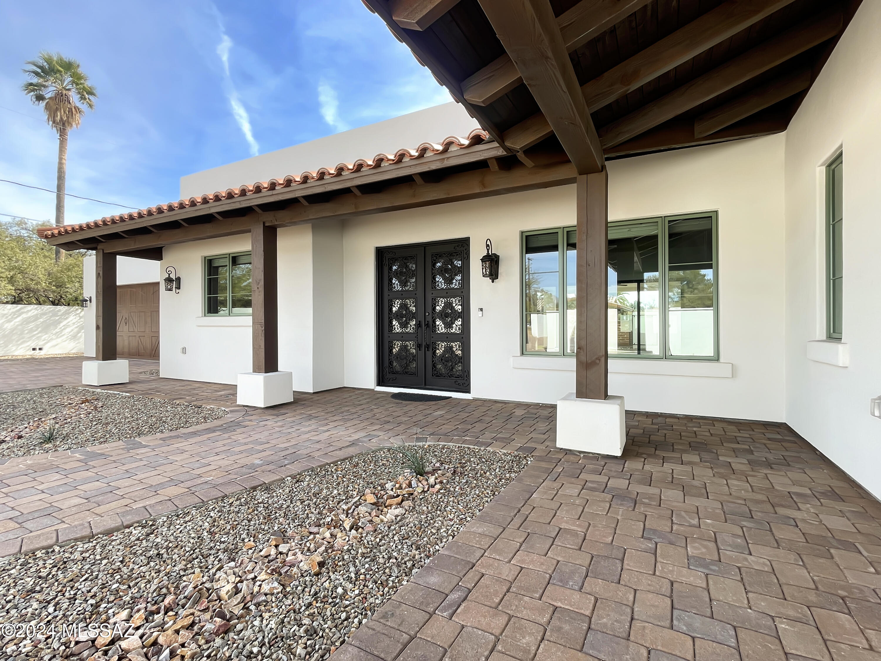 Beautiful front porch wraps around the entrance of this brand new construction Spanish revival home in Sam Hughes.  Only 8 blocks to the U of A and minutes from downtown Tucson attractions and nightlife.  Upon entrance you are in the great room with beamed ceiling, scored concrete floors, and feature fireplace with recessed shelves and special lighting. The sliding glass wall patio doors in front of you invites an indoor/ outdoor living experience on the beautifully paved patio.  Entertaining is simplified in this gorgeous kitchen.  A  pantry wall for all your storage needs and your counters kept clean with the microwave placed into the quartz countertop center island along with the wine fridge.  Plenty of room to spread out .  Butcher block counters compliment the perimeter and add warmth and depth to this amazing kitchen.  5 bedroom layout offers something for everyone - perhaps the gamer or ?? will like one room in particular- you will have to come see for yourself! 3 full size bathrooms are gorgeous - one being a Jack and Jill that will not mind being shared. This well crafted home is unique and private.  The paved driveway leads you to your gated special retreat, don't miss this opportunity in Sam Hughes Villas.