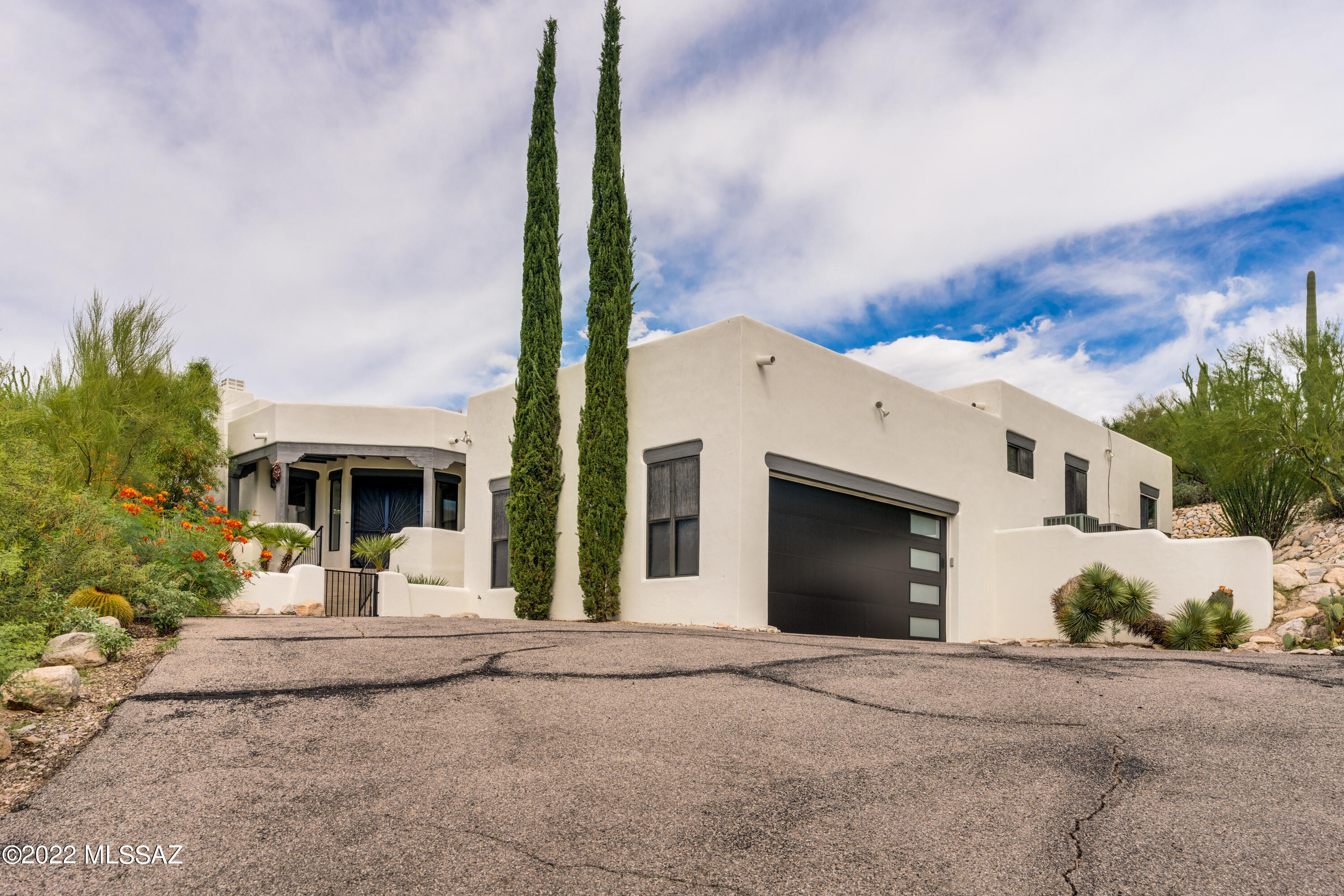 Beautiful home in the heart of the Catalina Foothills. Privacy, serenity  & mountain views await you on this .77 acre lot. Natural stone tile throughout all walkways & living spaces, engineered wood flooring in bedrooms. Lovely wood beamed ceilings & oversized windows to take in the views. Remodeled gourmet kitchen featuring gas cooktop, double ovens, large island, quartz counters & stainless steel appliances. Primary suite boasts spacious bedroom & sitting room, patio access, dual sink vanity, walk-in shower & large closet. Custom built in cabinetry in primary bath, closet & hall. Secondary  ensuite bedroom with single sink vanity & tub/shower, 2 additional bedrooms, remodeled full bath & powder bath. Enjoy the backyard with lagoon pool, turf, extensive patio. Hillside lot. Pool was drained, chlorine-washed & refilled in 7/22. Landscaping lighting conveys AS-IS