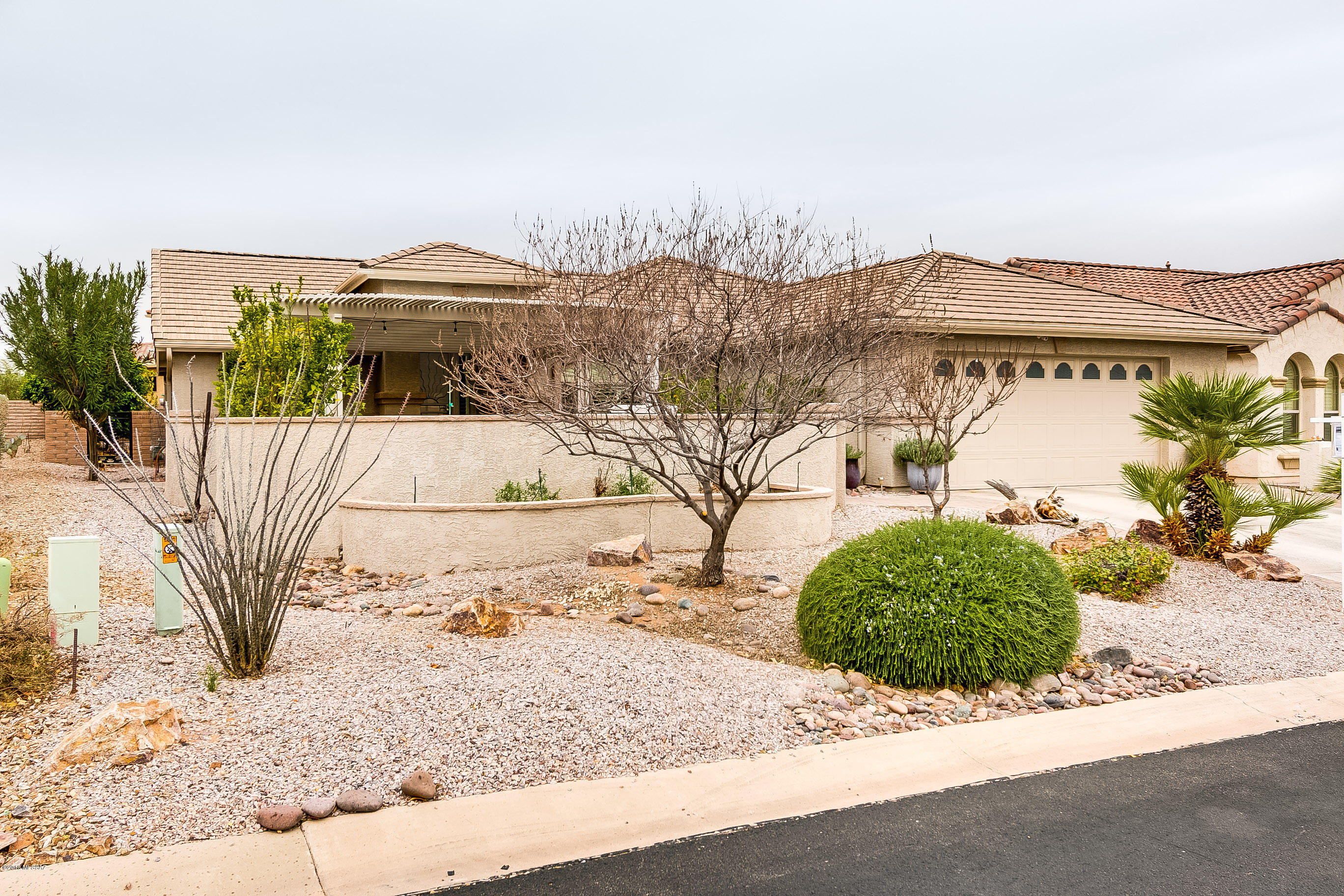 Beautifully expanded Laredo in one of the most sought after Adult Communities in Green Valley.  Recent Kitchen Remodel with all New Appliances including a Gas Range. New Trane Air Conditioner and Thermostat. Ramadas in both Front and Back that provide Shade while enjoying the 58 foot long ''Screened Arizona Room'', Great for Entertaining.  Upgrades include Flat Roof Tiles, floor to ceiling Garage Cabinets on both sides with 2 work stations, water softener, upgraded tile, Plantation Shutters through out, Remodeled Master Bath Shower, built-ins in master closet, 140 sq ft raised garden bed fully irrigated, fruit trees including: Peach, Nectarine, Grapefruit, Orange Lemon, Lime, Fig, Plum, Pluot, and Pomegranate.