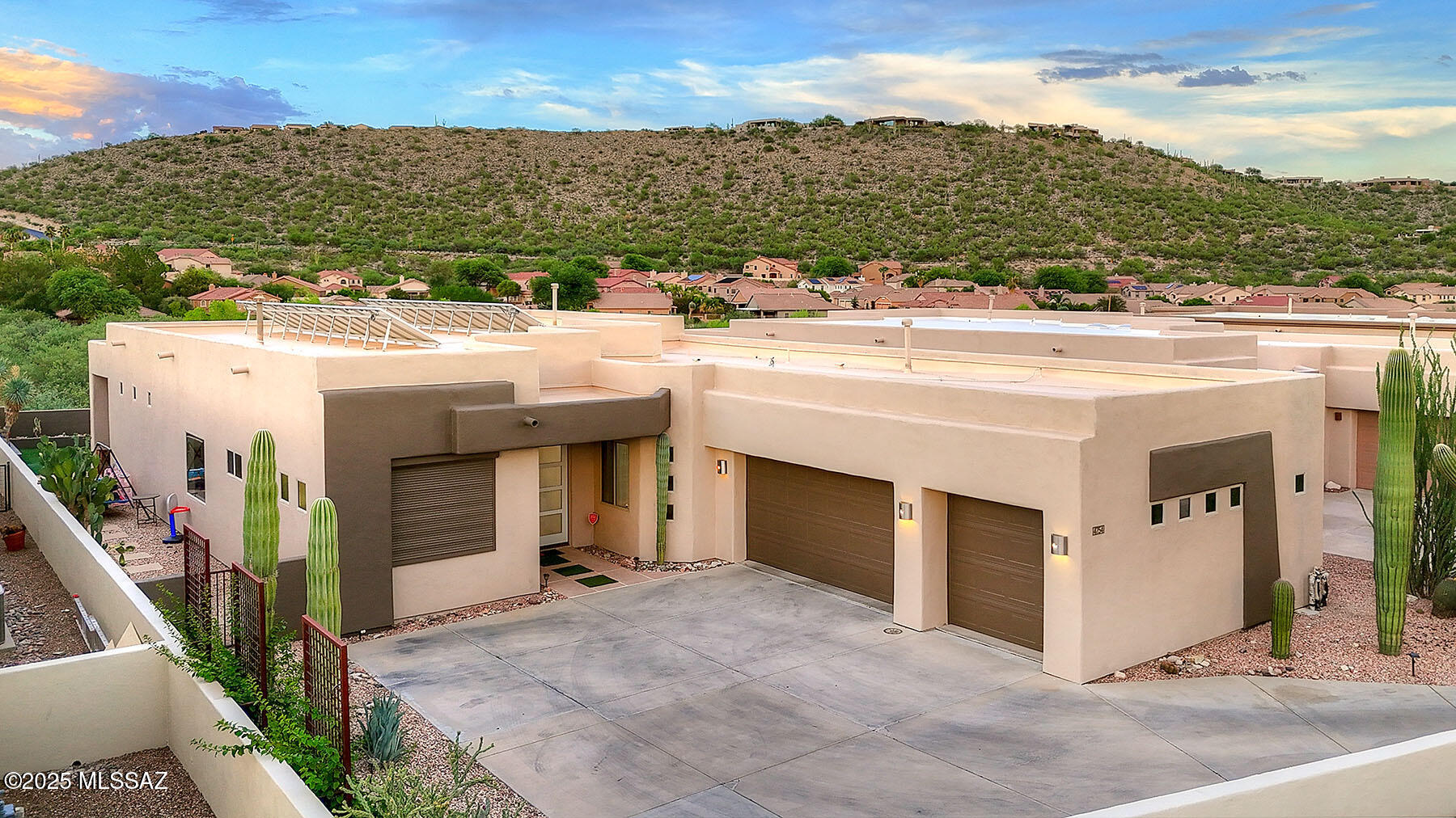 Enjoy beautiful Catalina Mountain views from this contemporary home in a small gated community near Sabino Canyon. The open floor plan features high ceilings, curved walls, travertine floors, and a stacked stone double-sided fireplace that anchors the living area. The kitchen offers maple cabinetry, granite countertops, stainless steel appliances, a walk-in pantry, and a large island. The remodeled primary suite provides mountain views, a spacious walk-in closet, and an updated bath with two separate vanities, walk-in shower, and modern finishes. Three additional bedrooms and two additional full baths provide space for guests or a home office. Step outside to a private backyard with a covered patio, turf area, above ground hot tub and an owned solar system.